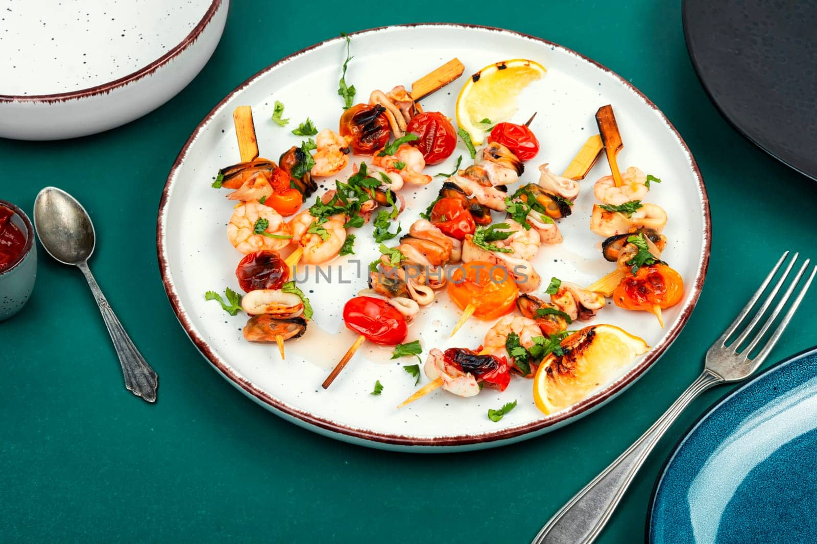 Grilled squid, fried mussels and shrimps on wooden skewers. Seafood appetizers. Flat lay, no people.