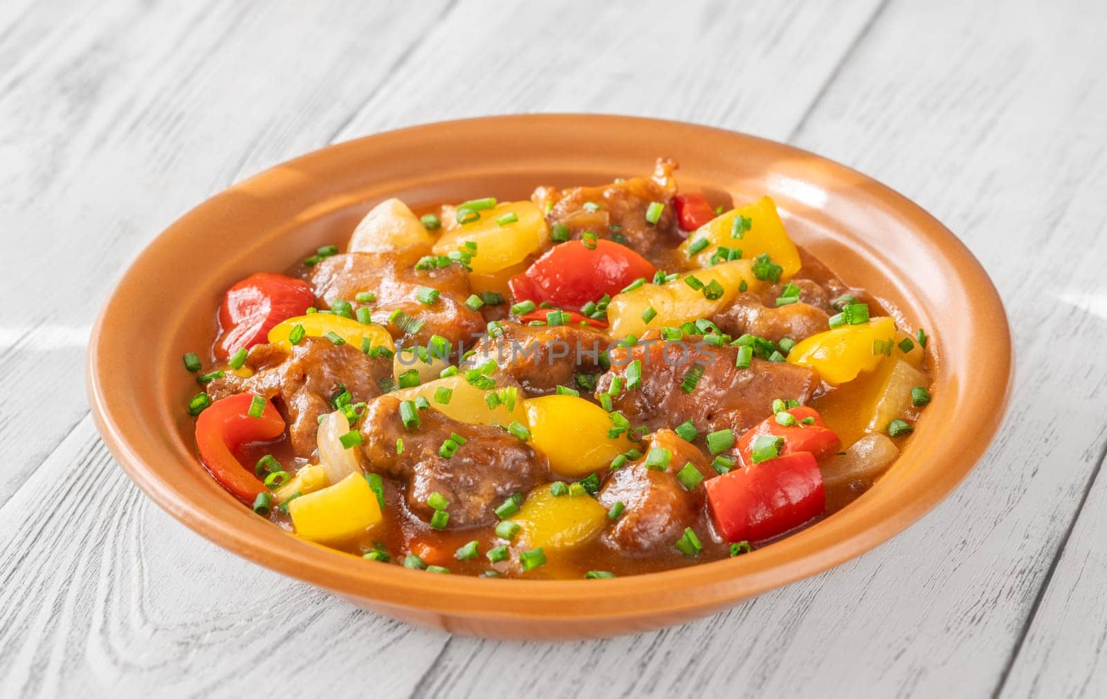 Portion of sweet and sour pork with bell pepper and pineapple