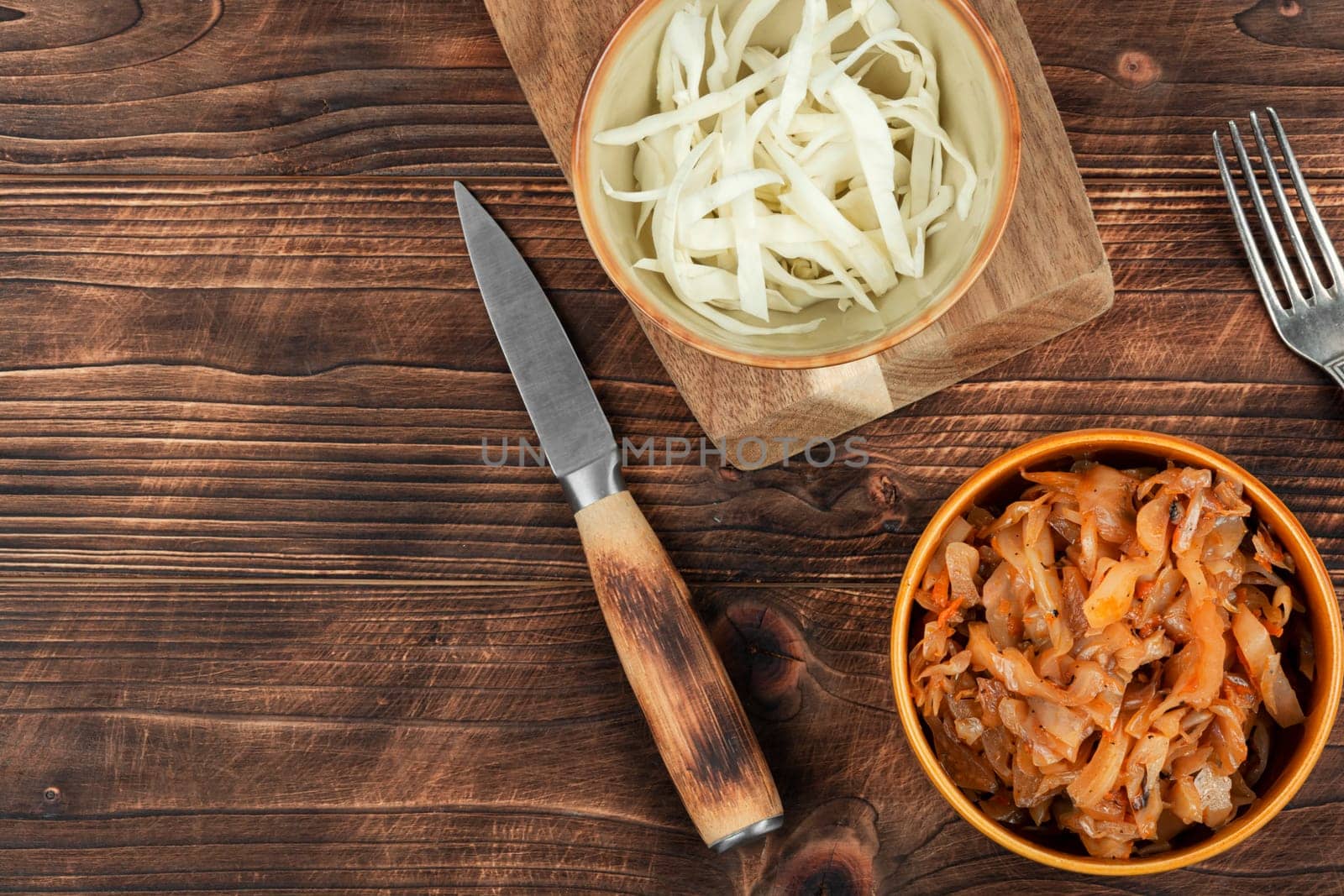Appetizing stewed cabbage on the old wooden background. Top view, copy space