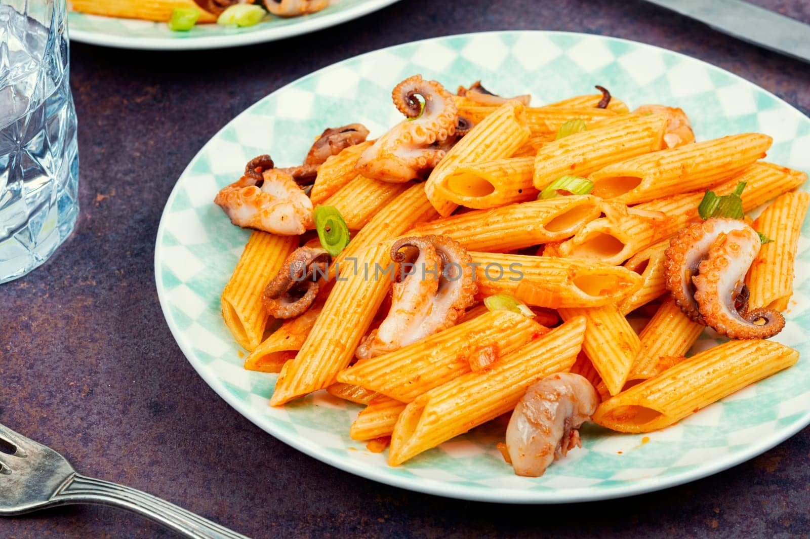 Appetizing macaroni or pasta boiled with octopus. Pasta with seafood. Close up.