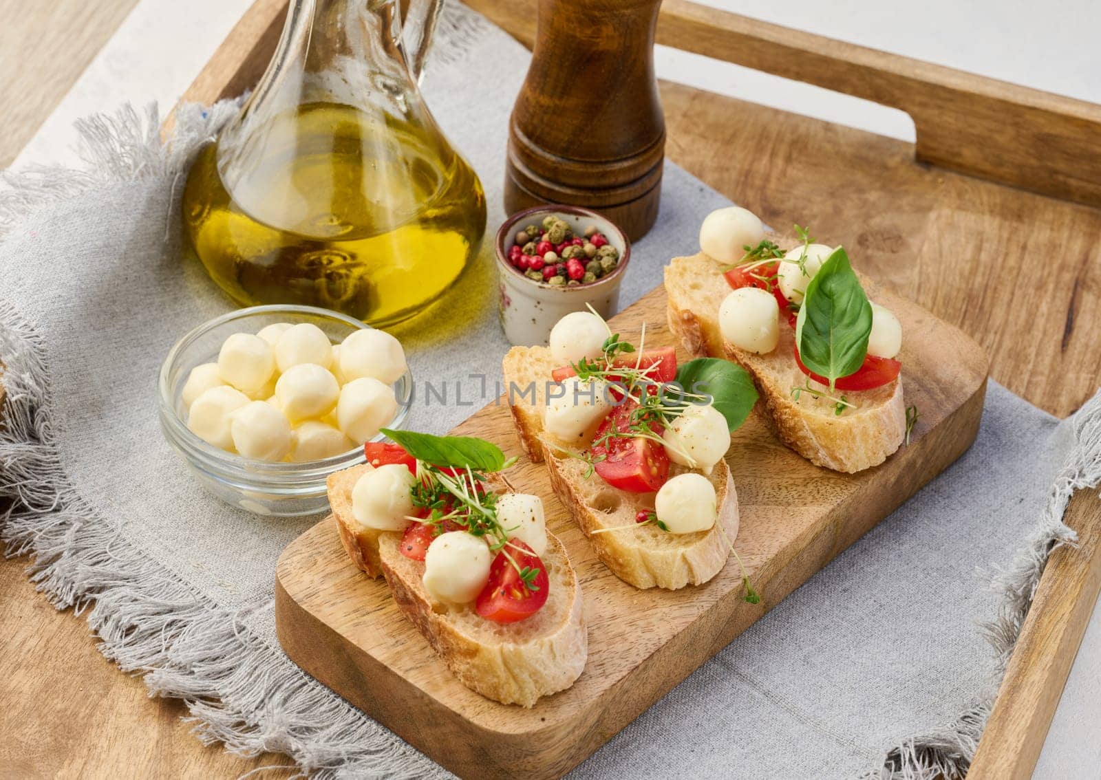 Round mozzarella, cherry tomatoes and microgreens on a piece of white bread, a healthy sandwich