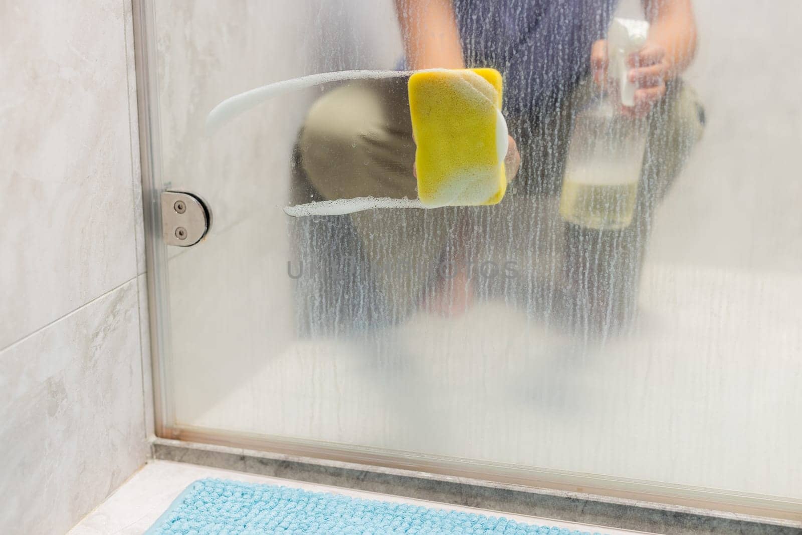Hands are cleaning windows with sponge and detergent