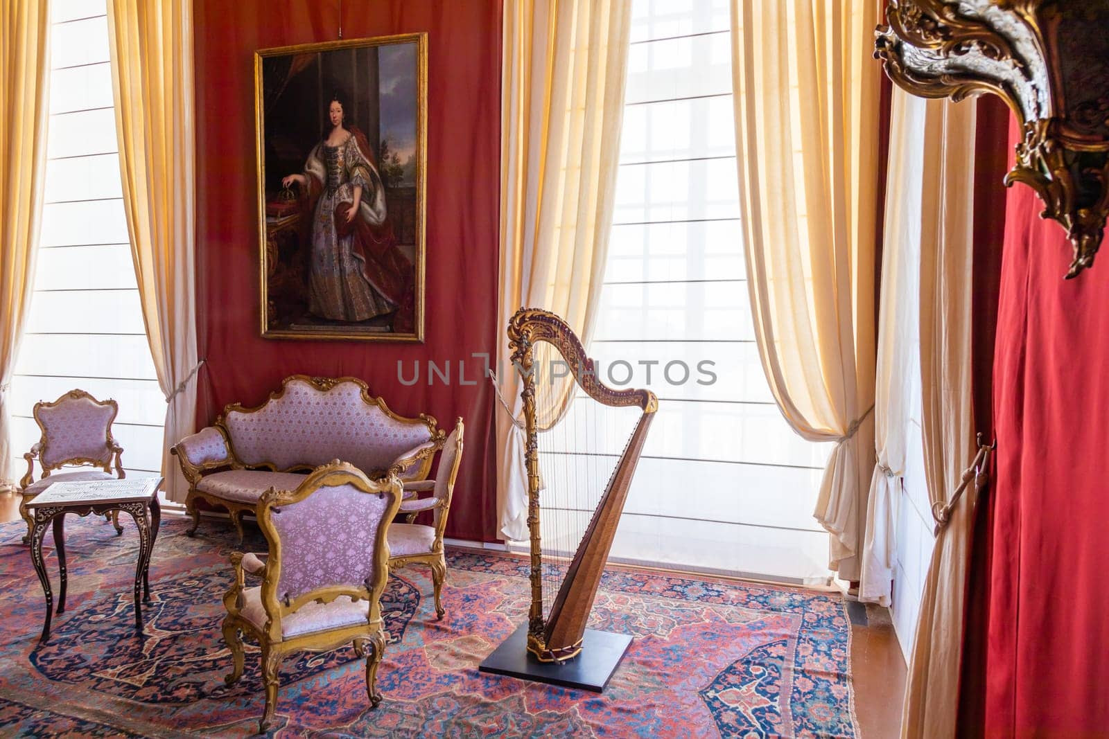 Venaria Reale, Italy - February 2023: luxury interior, old Royal Palace. Perspective with harp, window and baroque decoration.