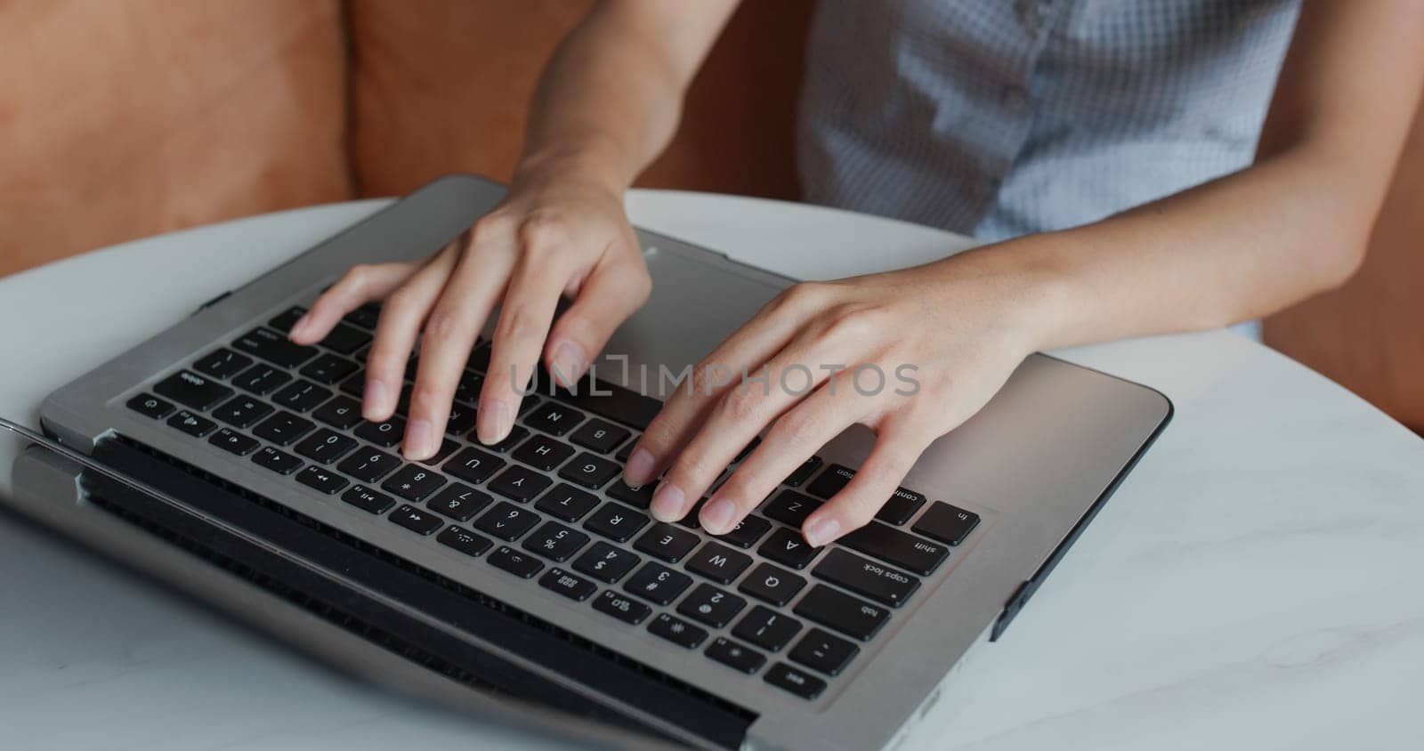 Woman types on laptop computer at home