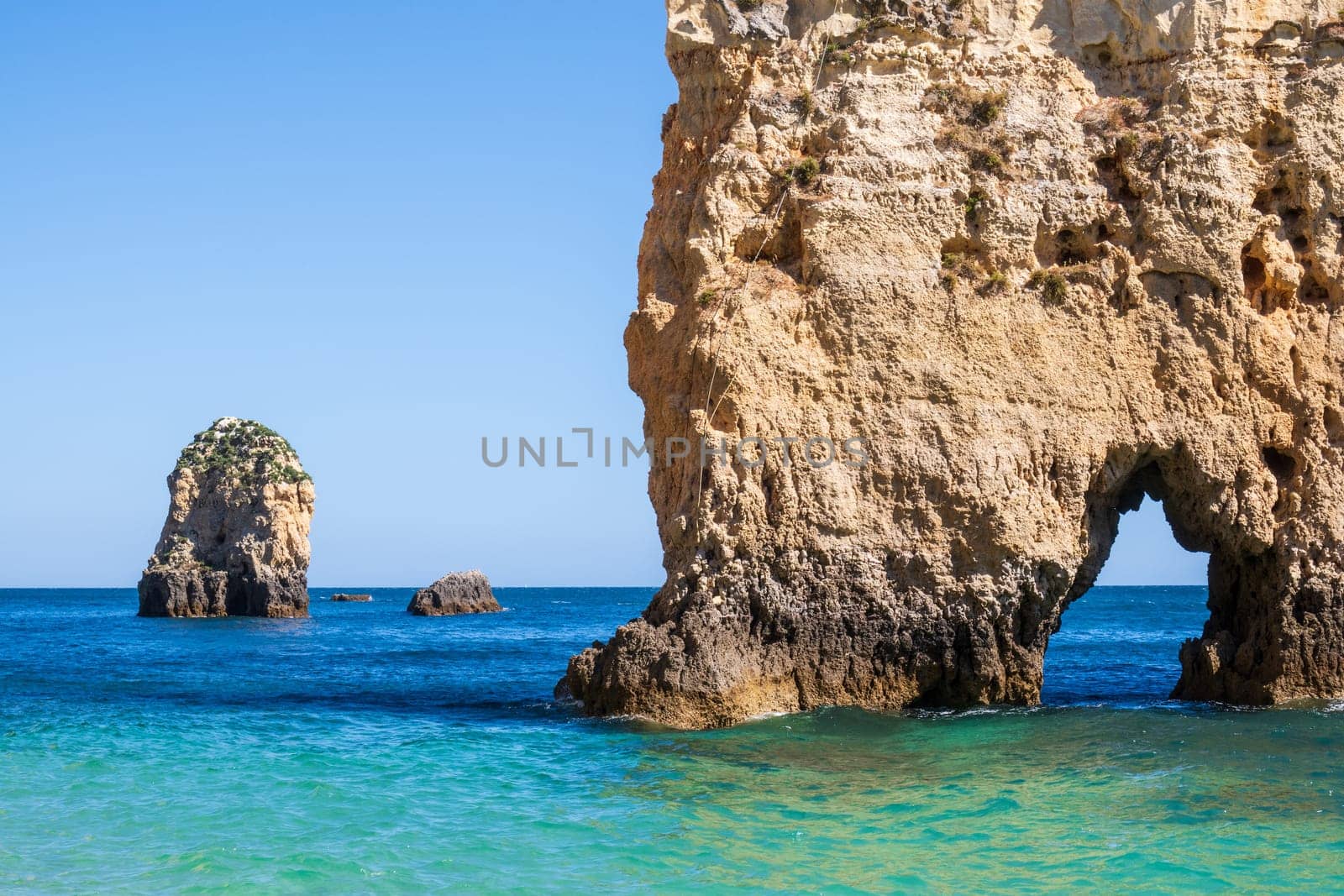 Balanced complementary symmetry of rocks at a heavenly beach photographed near Portimão, Algarve, Portugal