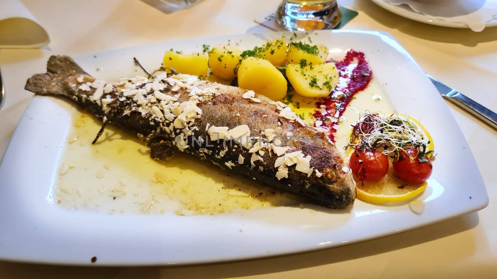 Gegrillte ganze Forelle, Kartoffeln, Zitrone und Knoblauch, Nahaufnahme