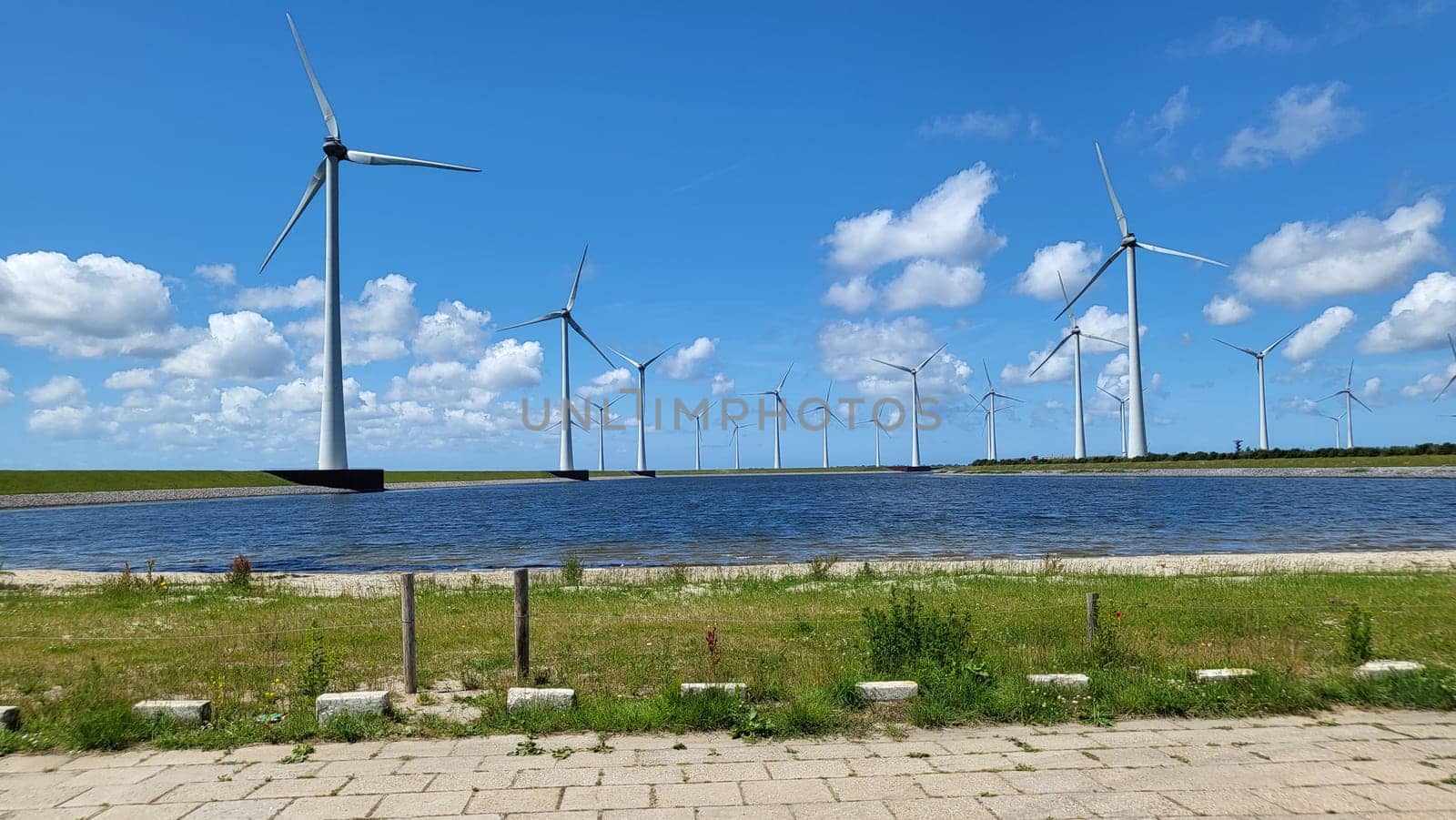 Offshore windmill farm in the ocean Westermeer wind farm, windmills isolated at sea on a beautiful bright day Netherlands Flevoland Noordoostpolder. Huge windmill turbines