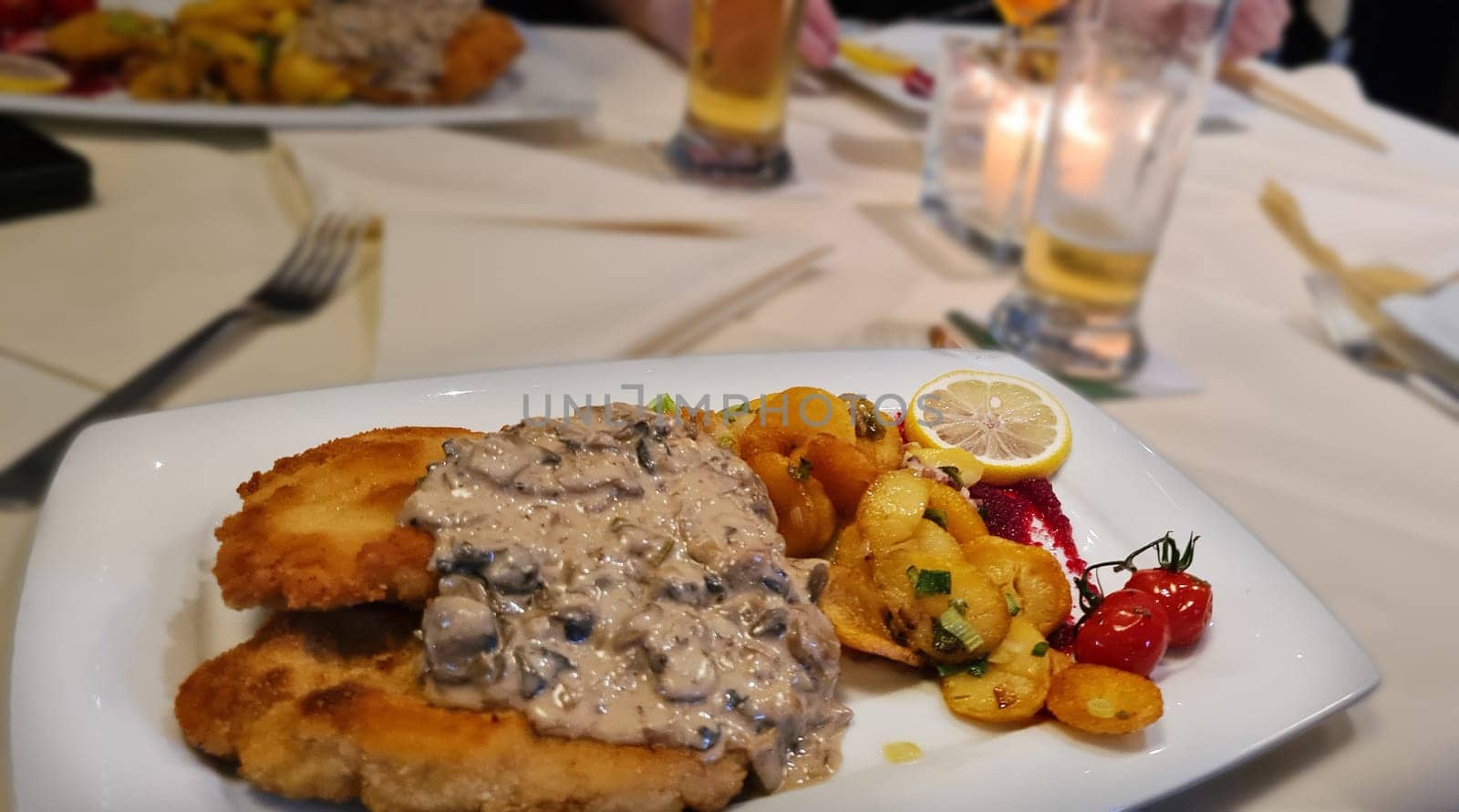 Traditional Jägerschnitzel with mushroom sauce and fried potatoes. German cuisine