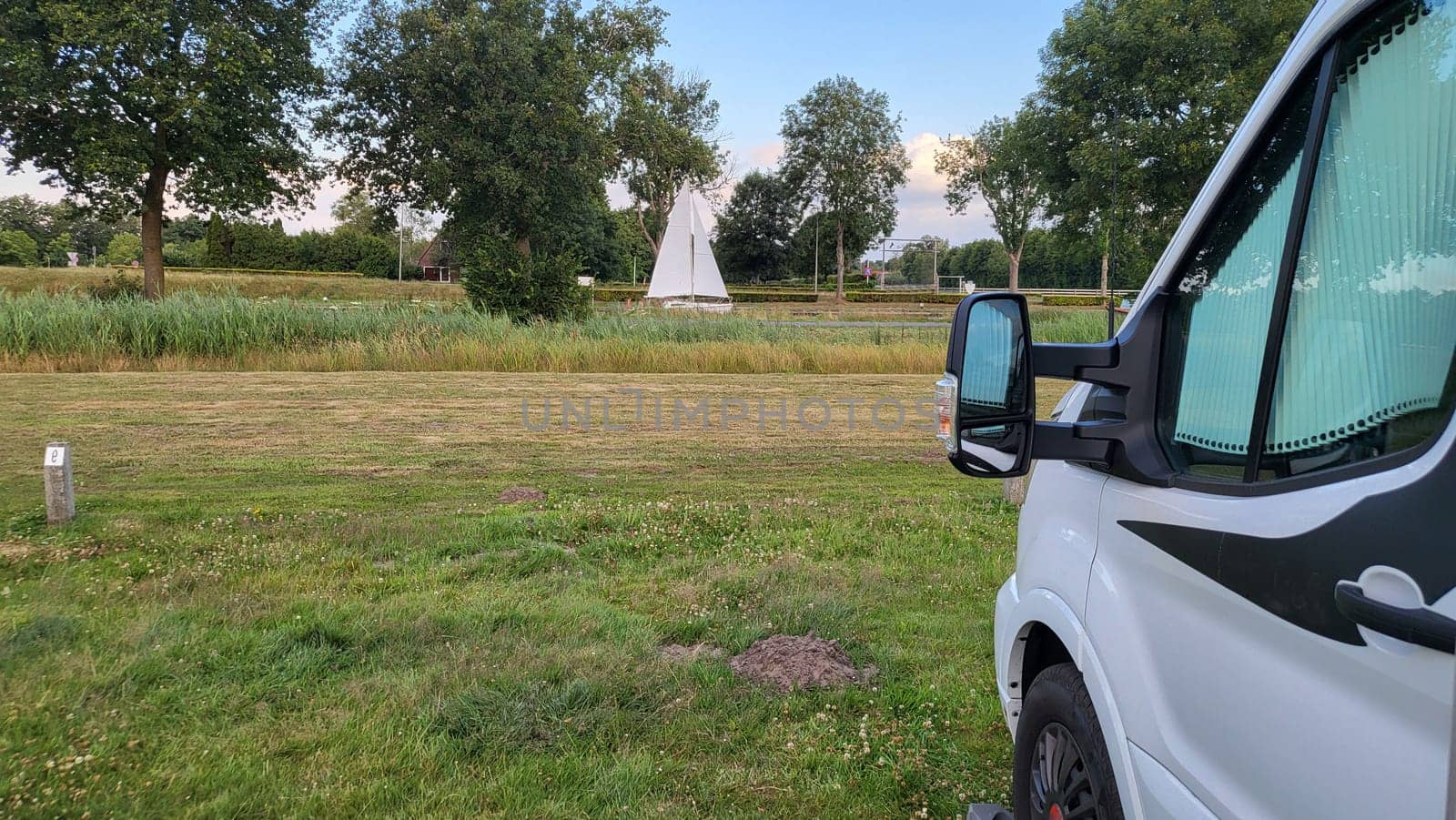 Caravan recreational vehicle at sunrise in Urk Holland. Camping on the natural beach. Vacation and travel in a mobile home
