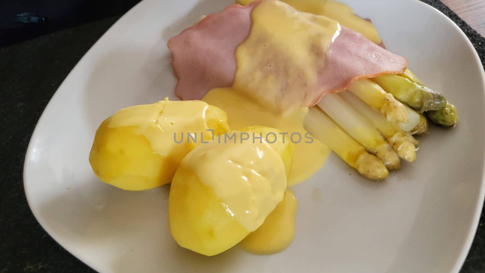 Asparagus served on a plate with potatoes.