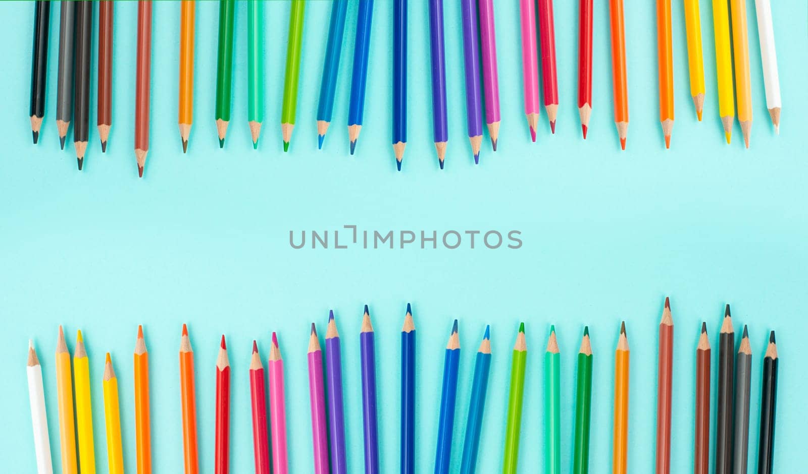 Color pencils collection in a row, back to school, drawing supplies, blue background with copy space
