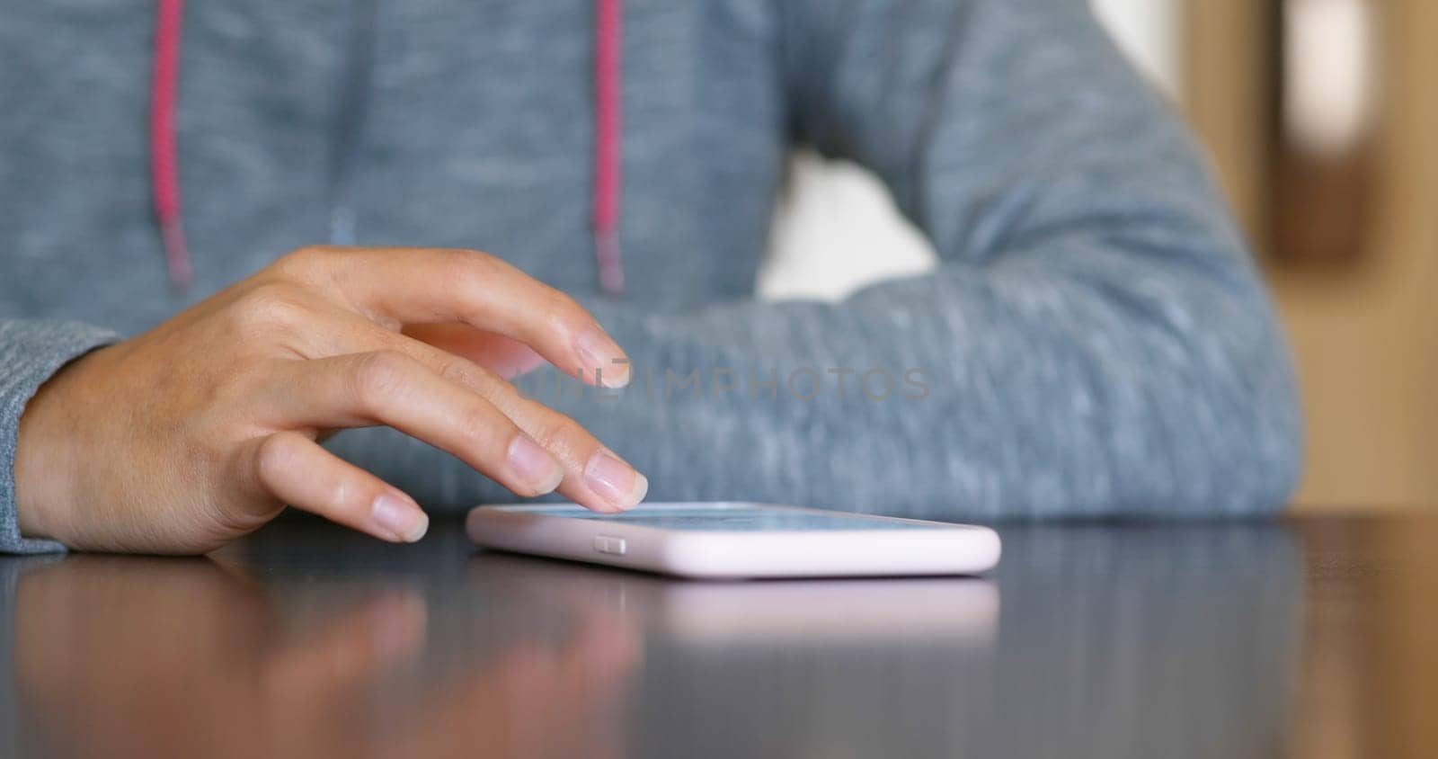 Woman use of smart phone and sit on the table