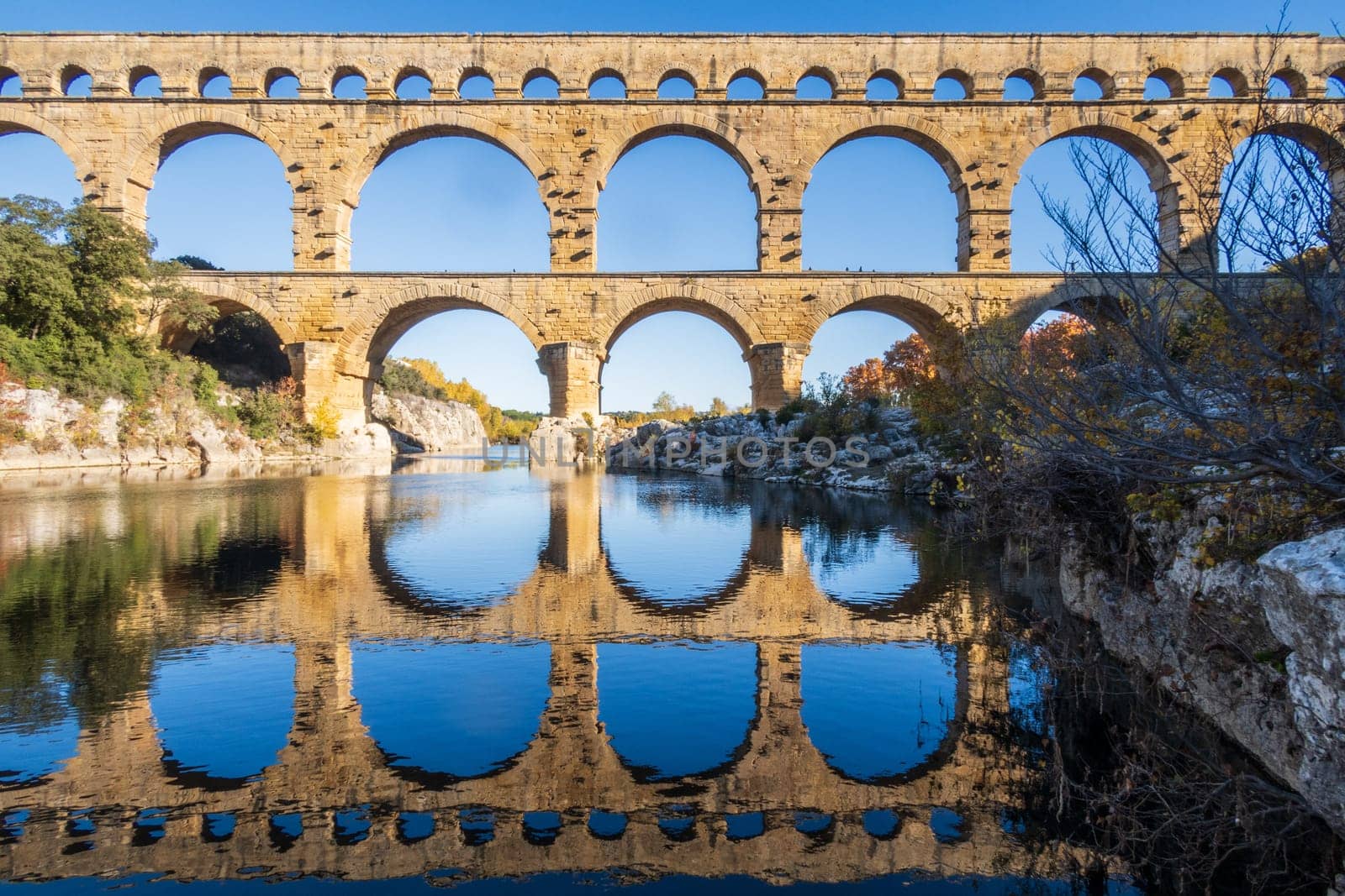 The Pont du Gard over Gardon river. Ancient Roman three-tiered aqueduct bridge. Photography taken in Vers-Pont-du-Gard, Provence, southern France