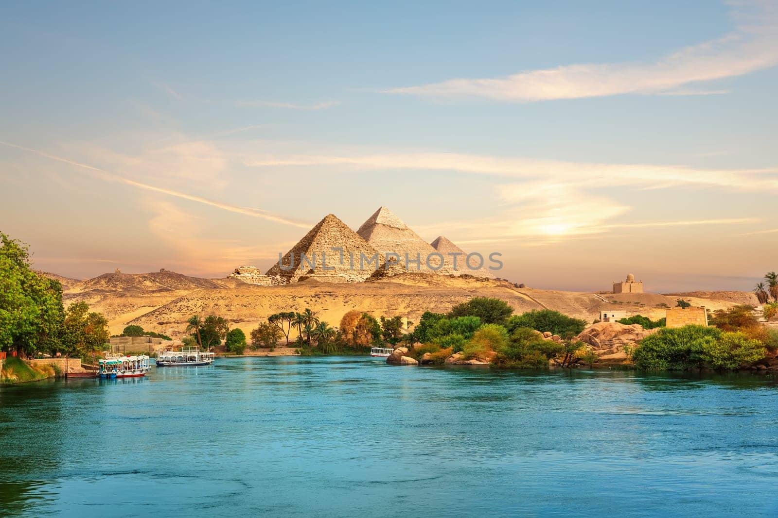 View on the Nile and the boats at sunset in the Aswan desert near the Pypamids of Egypt.