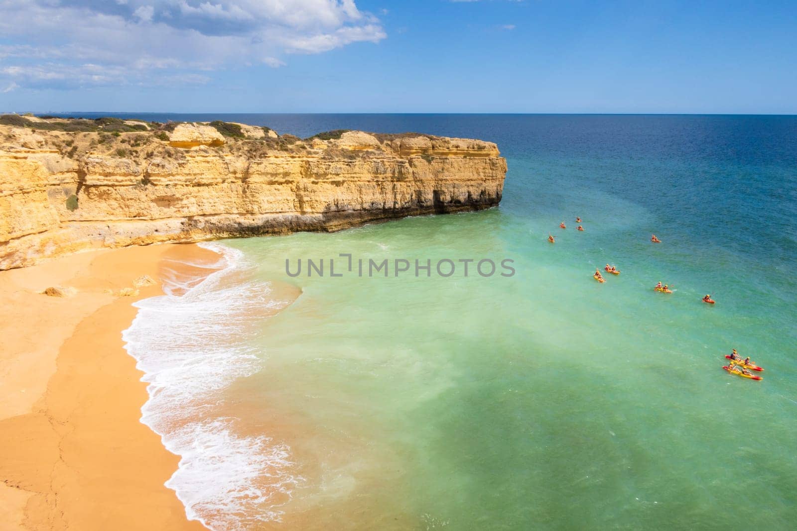 View of cliffs and canoes on ocean, Praia da Ponta Pequena beach near Albufeira, Portugal