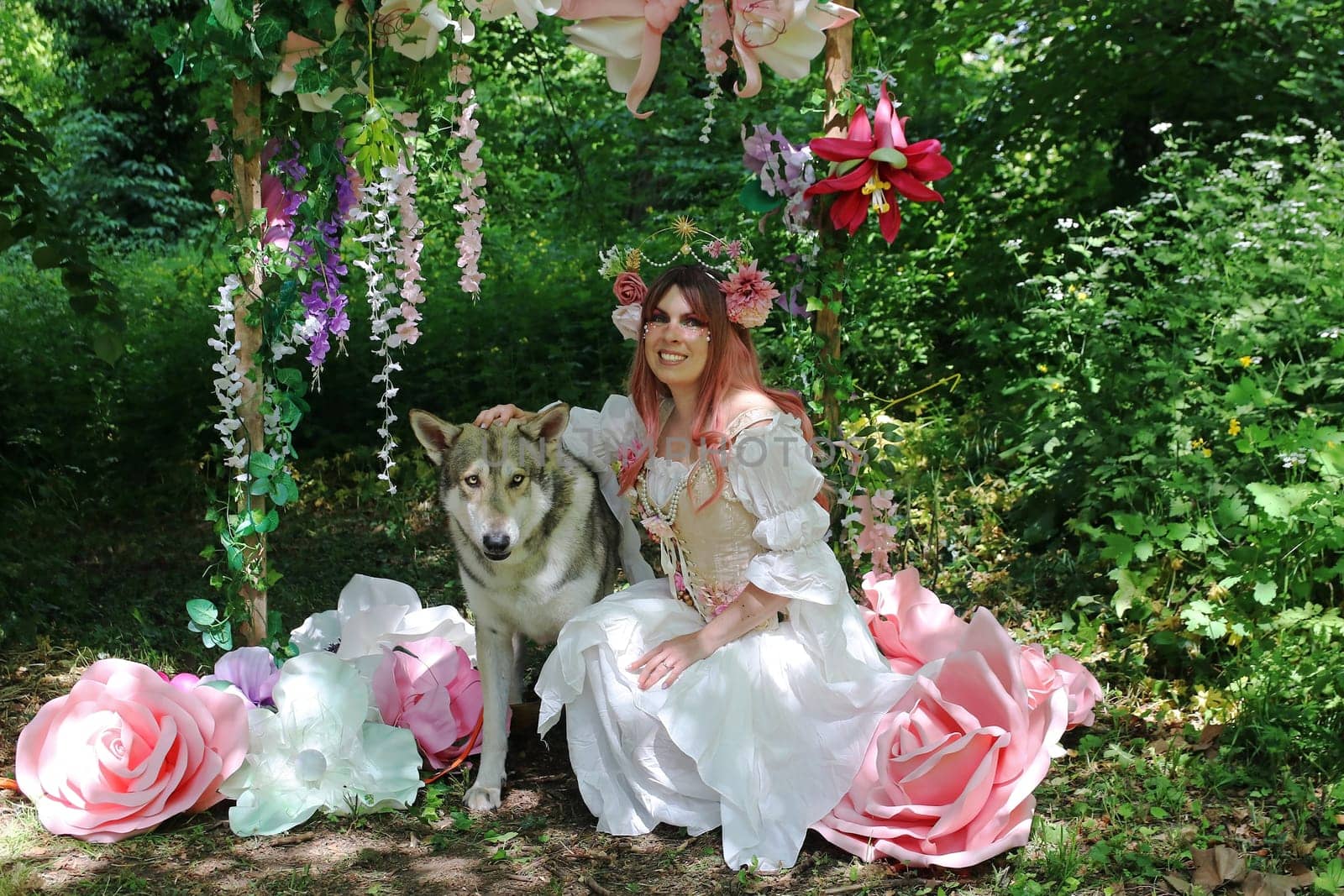 A young laughing woman dressed as a fairy with a wolfhound