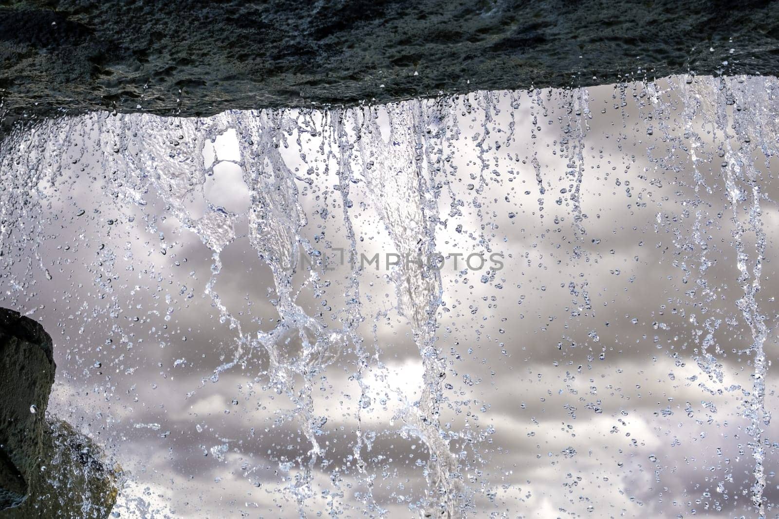 Detail of artificial waterfall in a swimming pool in summer