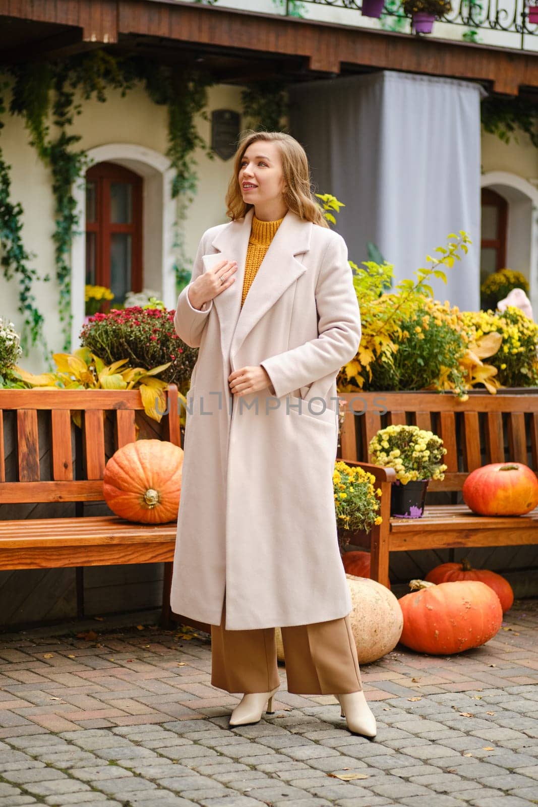 Young woman with unfastened coat at pumpkin festival