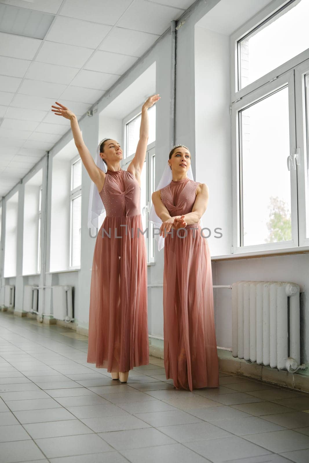Two ballet dancers rehearsing choreography in the hallway