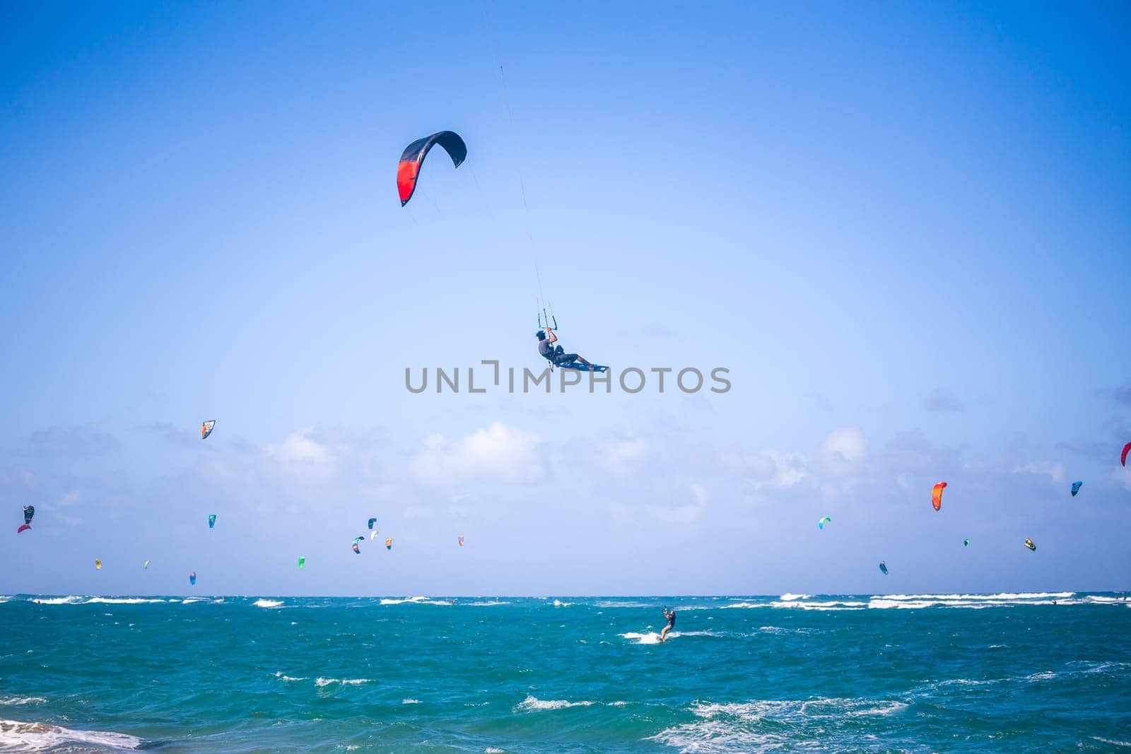 Kiteboarding. Fun in the ocean. Extreme Sport Kitesurfing. Kitesurfer jumping high in the air performing triks during kitesurfing session