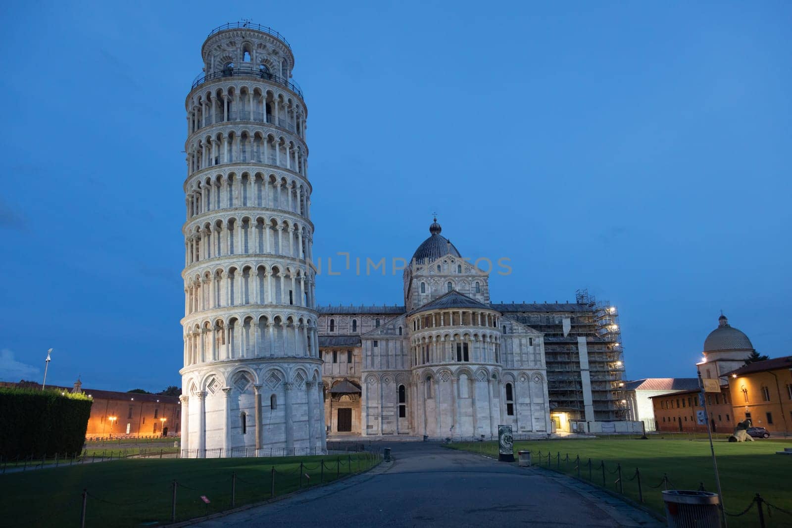 Pisa, Italy - 01 July 2023: leaning tower and cathedral panorama by night, blue sky