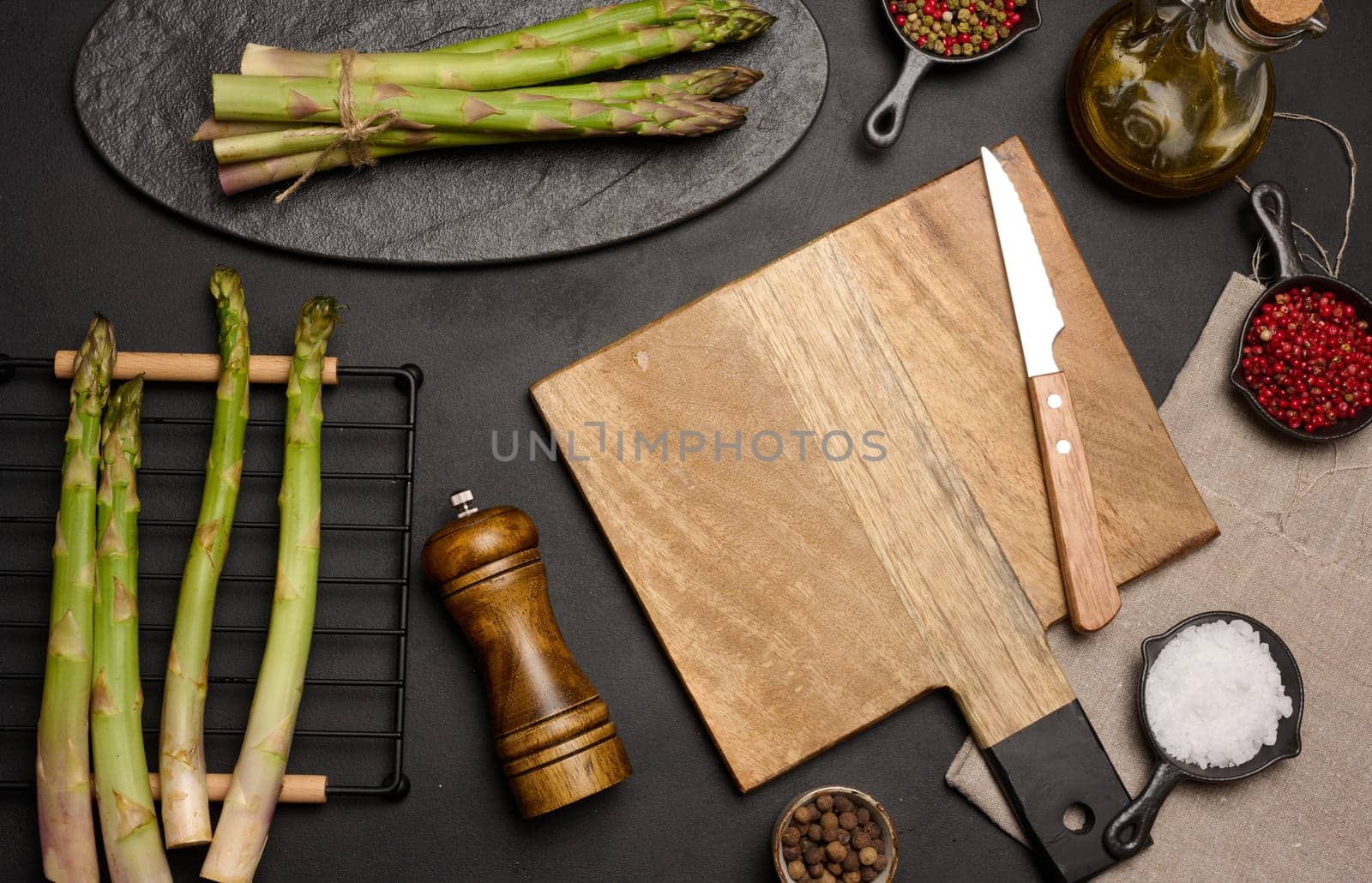 Fresh green asparagus sprouts on a black wooden background. View from above