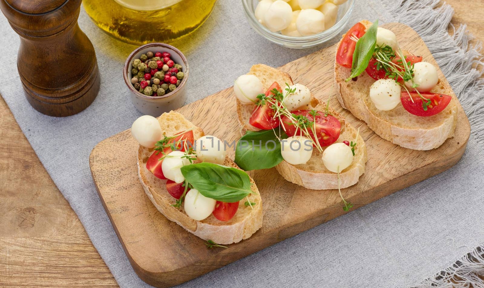 Round mozzarella, cherry tomatoes and microgreens on a piece of white bread, a healthy sandwich