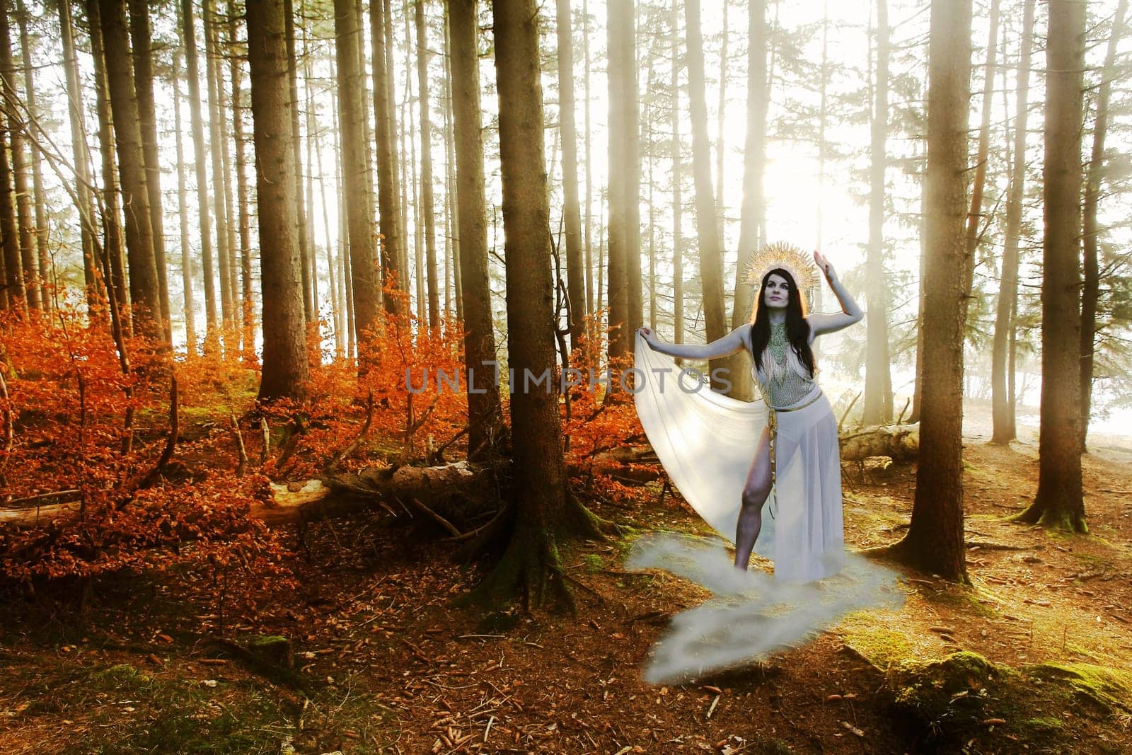 A woman as a goddess stands on a cloud in the forest, backlit by the sun