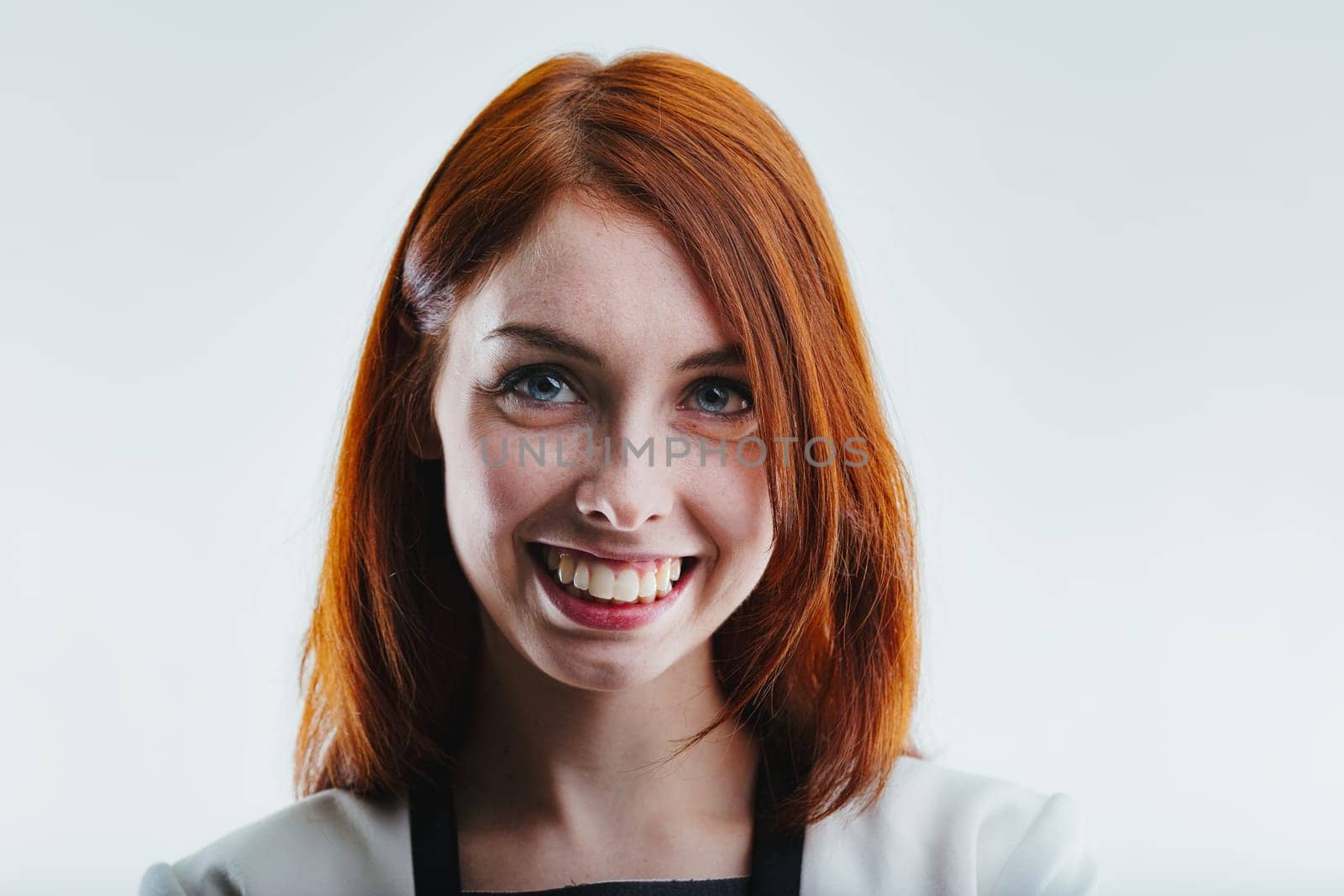 Cheerful redhead, white blazer, vibrant welcoming smile