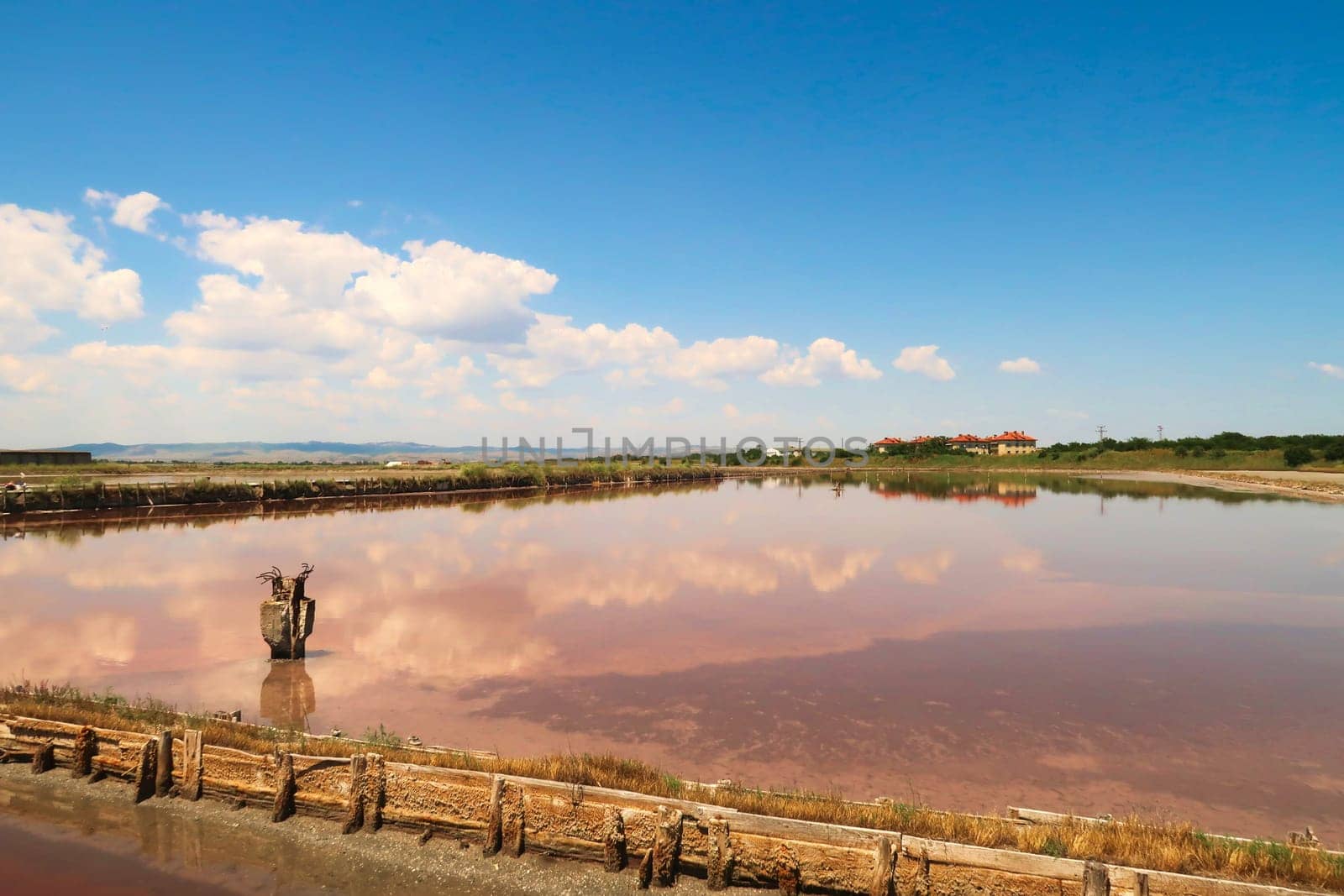 Perfect reflection of sky and clouds in the smooth surface of one of the pink pools at the Burgas Salt Pans at Lake Atanasovsko, Atanasovo, Burgas, Bourgas, Bulgaria 2022