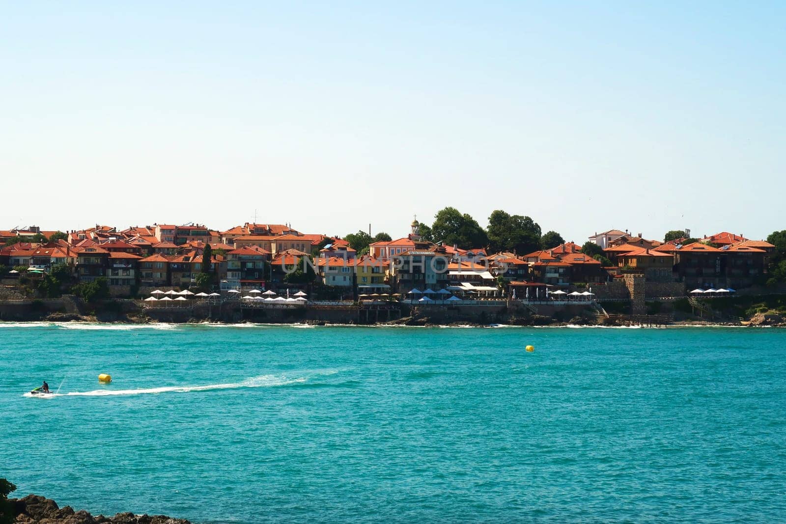 The old town of Sozopol, Sosopol next to the Sozopol Central Beach, water sports on the intense blue turquoise water in the foreground, Bulgaria 2022
