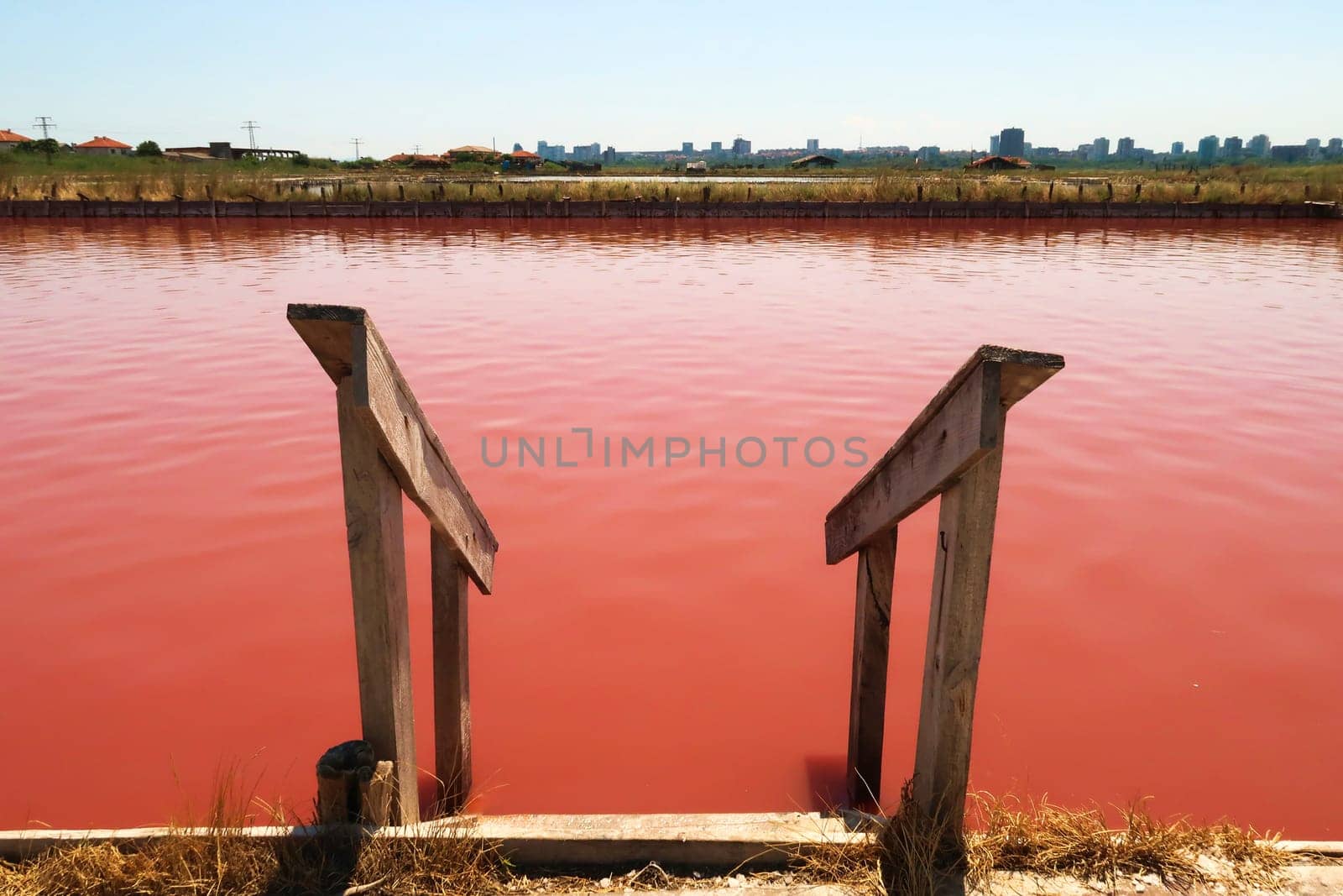 Stairs leading into the main bathing, swimming pool with its intense pink color at the Burgas Salt Pans, Lake Atanasovsko, Atanasovo, Burgas, Bourgas, Bulgaria 2022