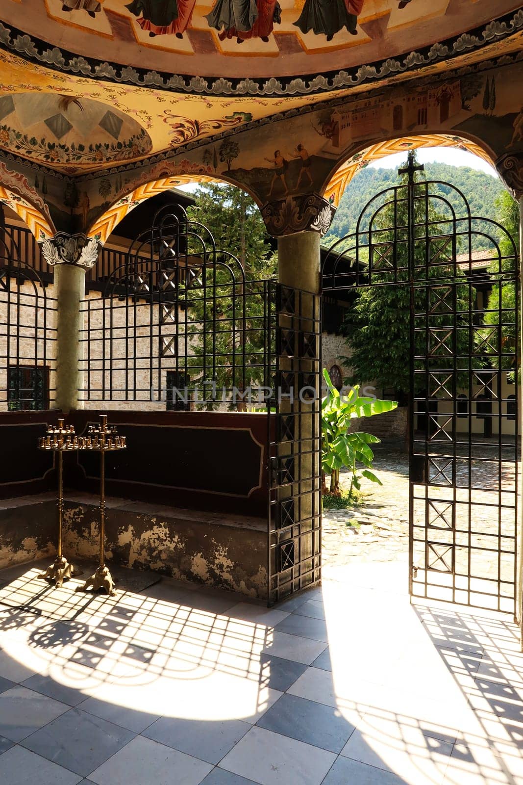 Beautiful entrance area of the St., Saint Nicolas, Nikola Church in one of the courtyards of the Bachkovo Monastery, frescos, ceiling paintings, pillars and elaborate metal grids, close to Plovdiv, Bulgaria 2022