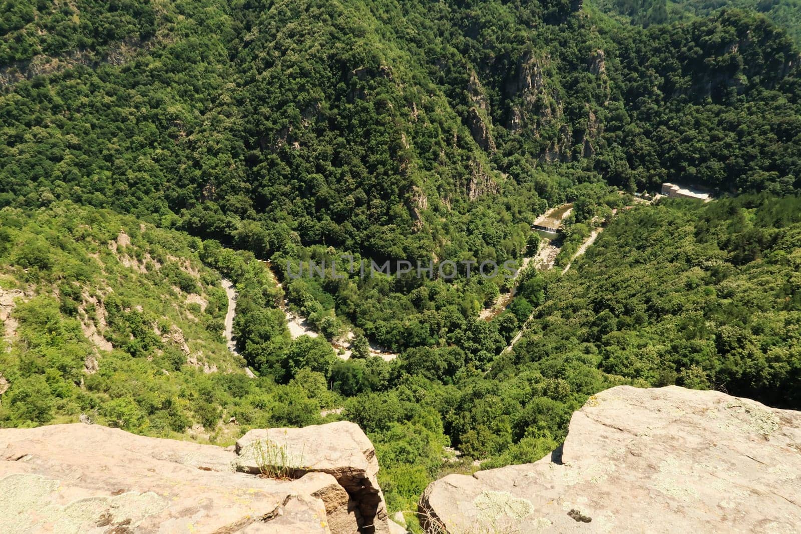 Spectacular view from the hiking trail between Asen's, Asens Fortress and the Bachkovo Monastery down onto the gorge of the winding Chepelare river, a hydroelectric power plant, dam can be seen, near Plovdiv, Bulgaria 2022