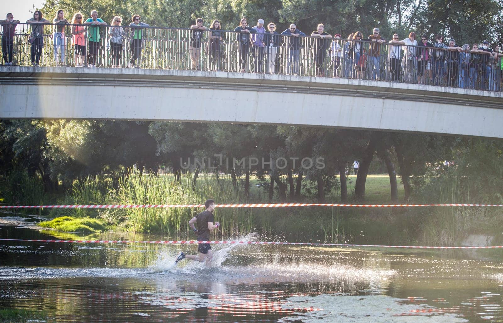 Merida, Spain - May 18th, 2024: FarinatoRace Merida 2024, Participant crossing the Albarregas river