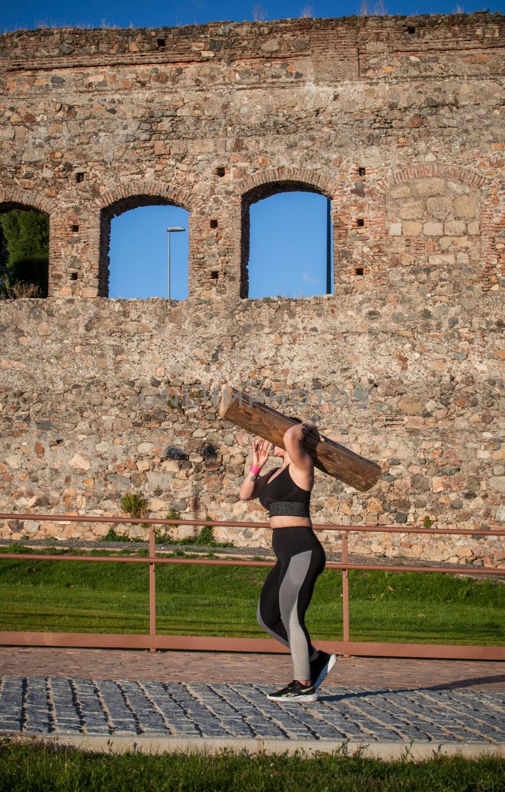 Merida, Spain - May 18th, 2024: FarinatoRace Merida 2024. Woman carrying a heavy log on his shoulder