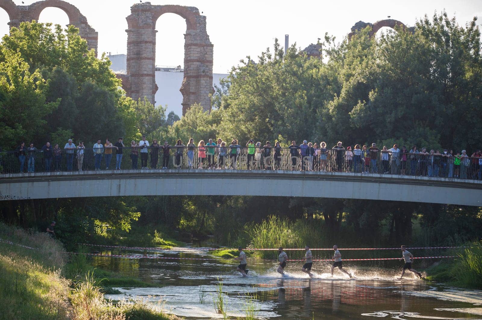 Merida, Spain - May 18th, 2024: FarinatoRace Merida 2024, Participants crossing the Albarregas river