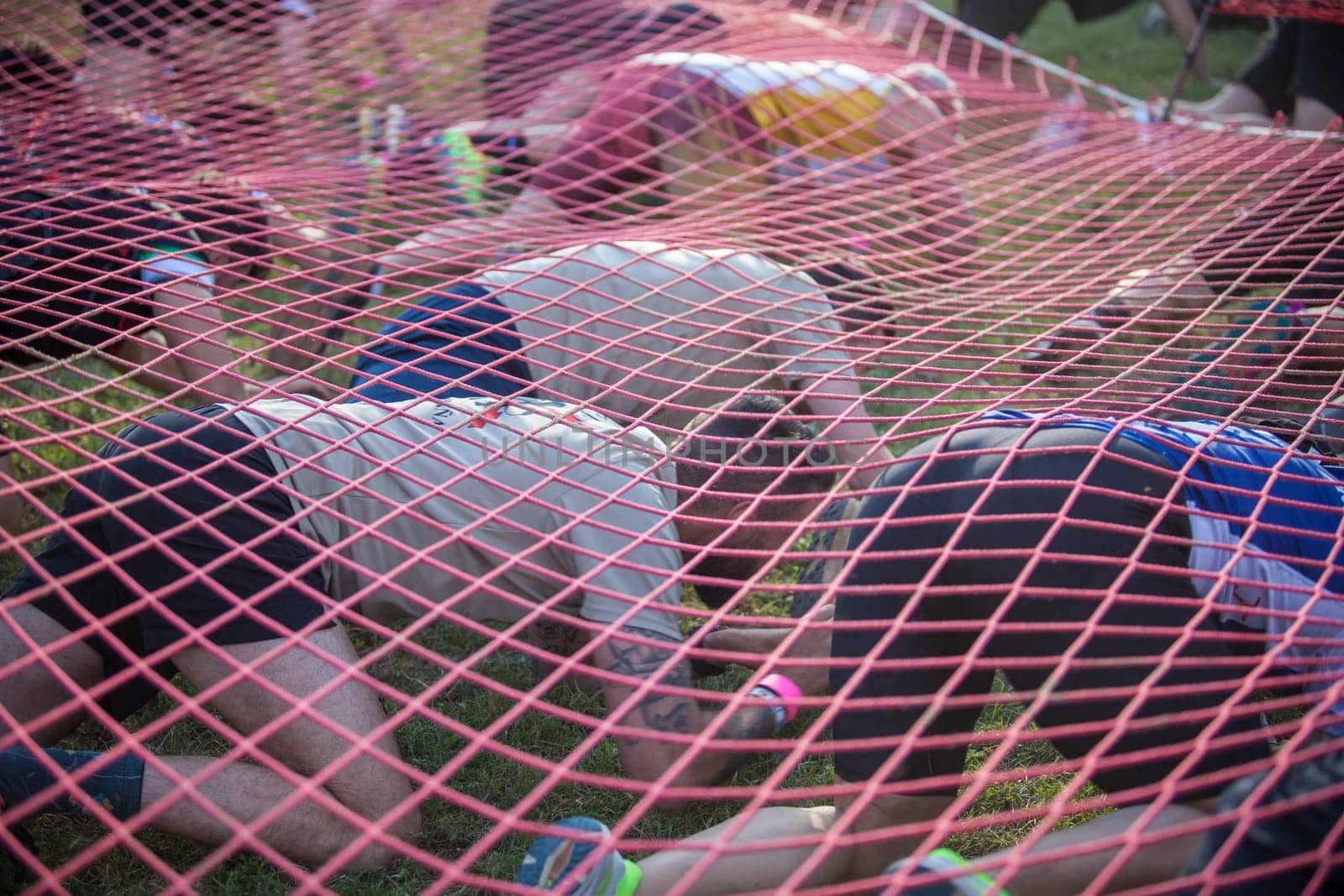 Merida, Spain - May 18th, 2024: FarinatoRace Merida 2024. Participants crawling under a net