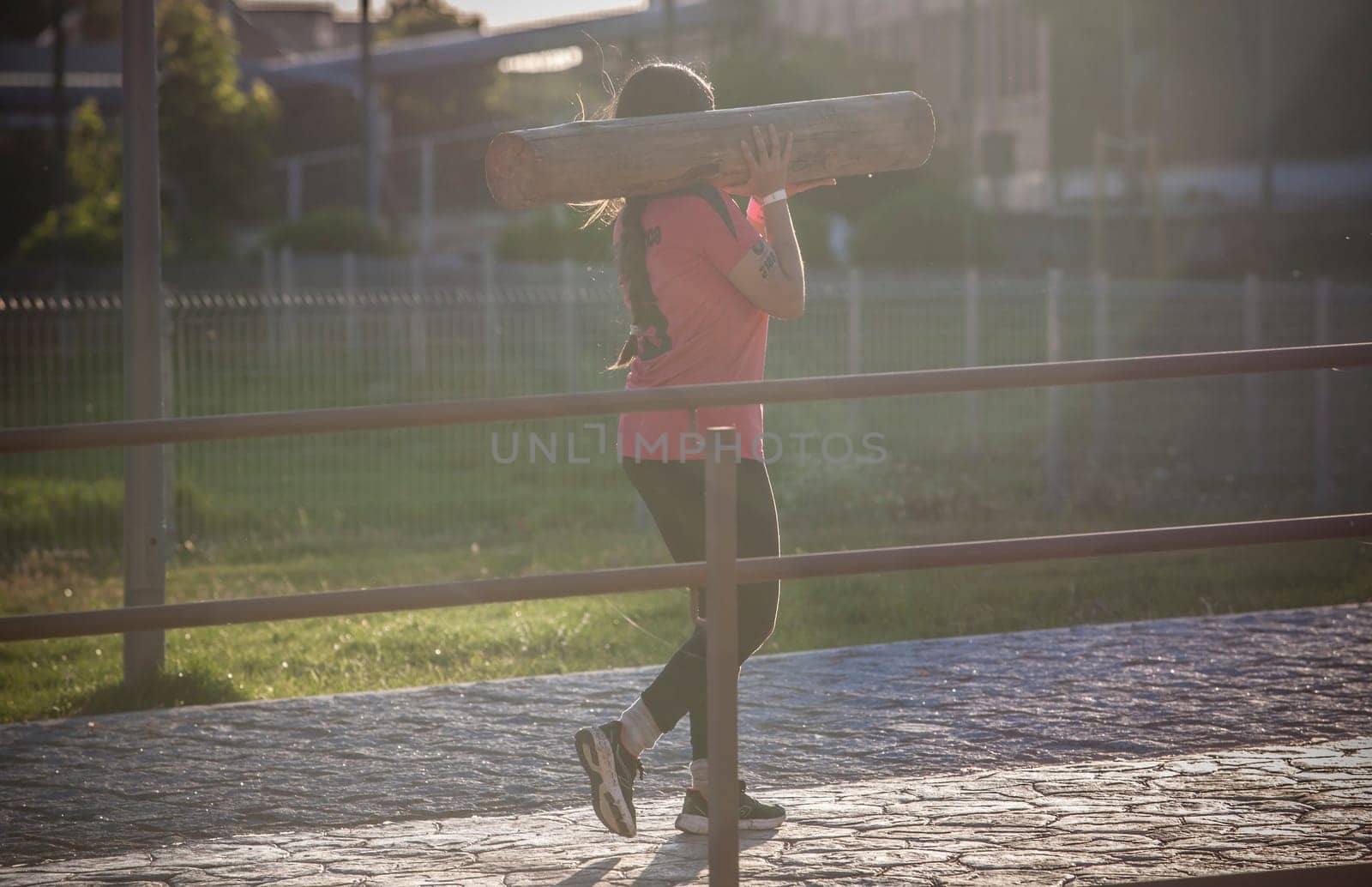 Merida, Spain - May 18th, 2024: FarinatoRace Merida 2024. Participant carrying a heavy log on his shoulder