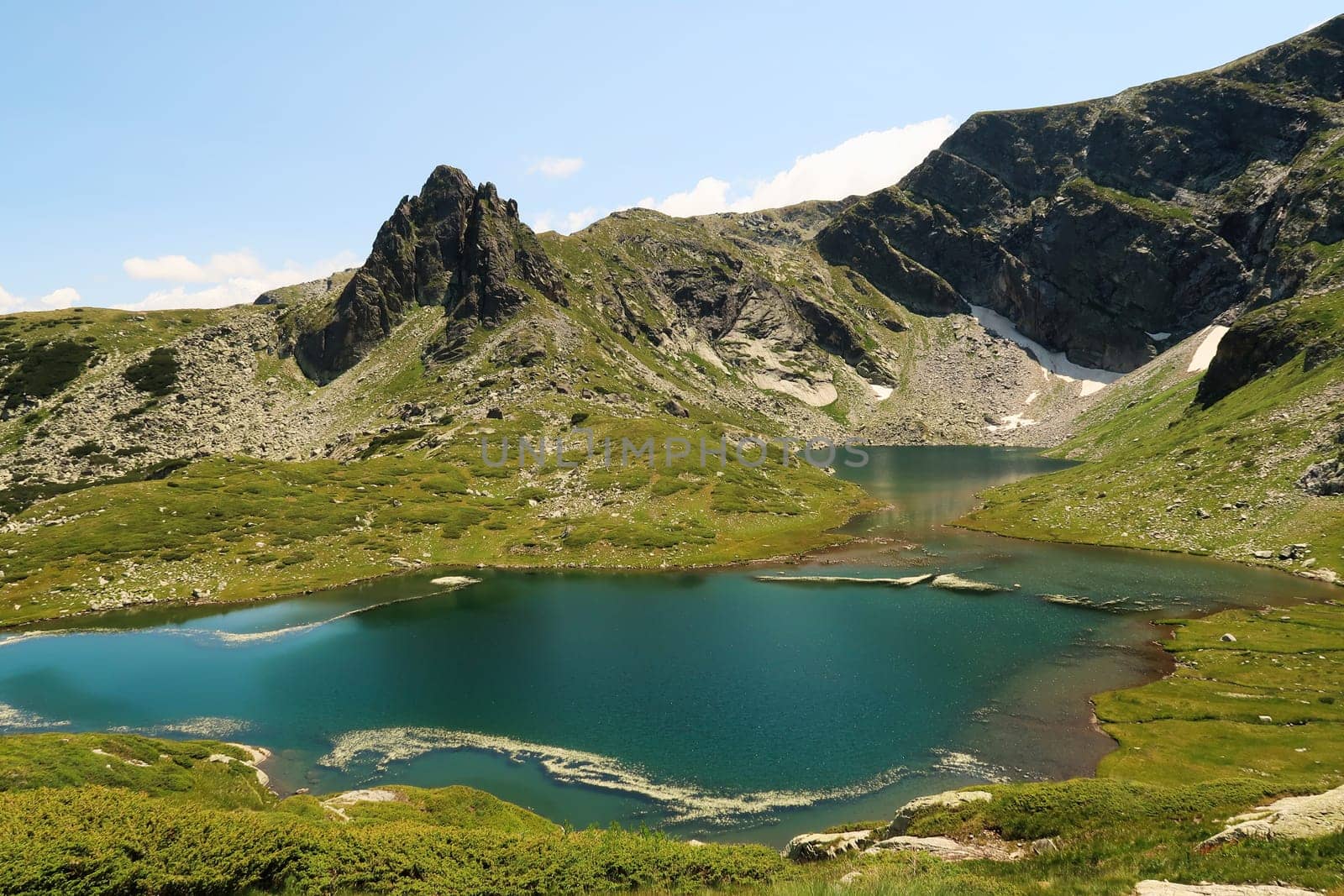 Spectacular view onto the deep blue, turquoise Fish Lake, Ribnoto Ezero and the mountains behind it, one of the Seven Rila Lakes in the Rila National Park, close to Sofia, Bulgaria 2022