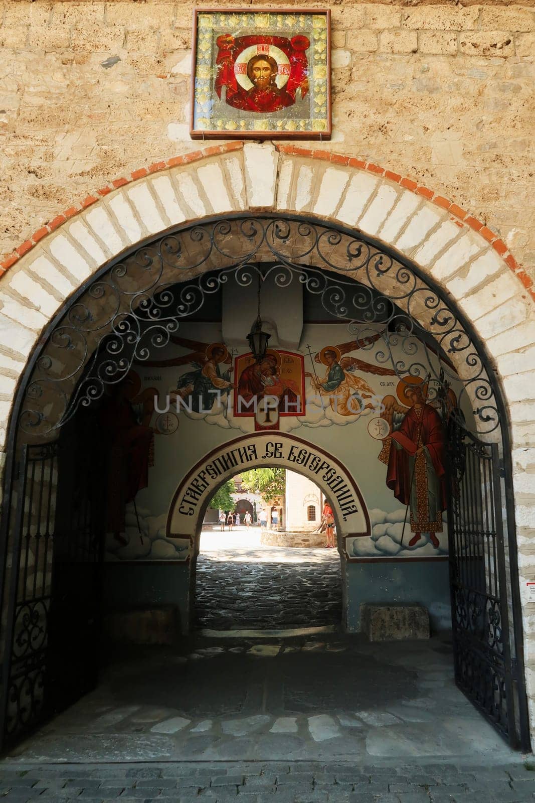 Entrance gate to the Bachkovo Monastery covered with a colorful fresco, wall painting depicting Archangel Michael and Gabriel attending the birth of Jesus, close to Plovdiv, Bulgaria, 16th of July 2022