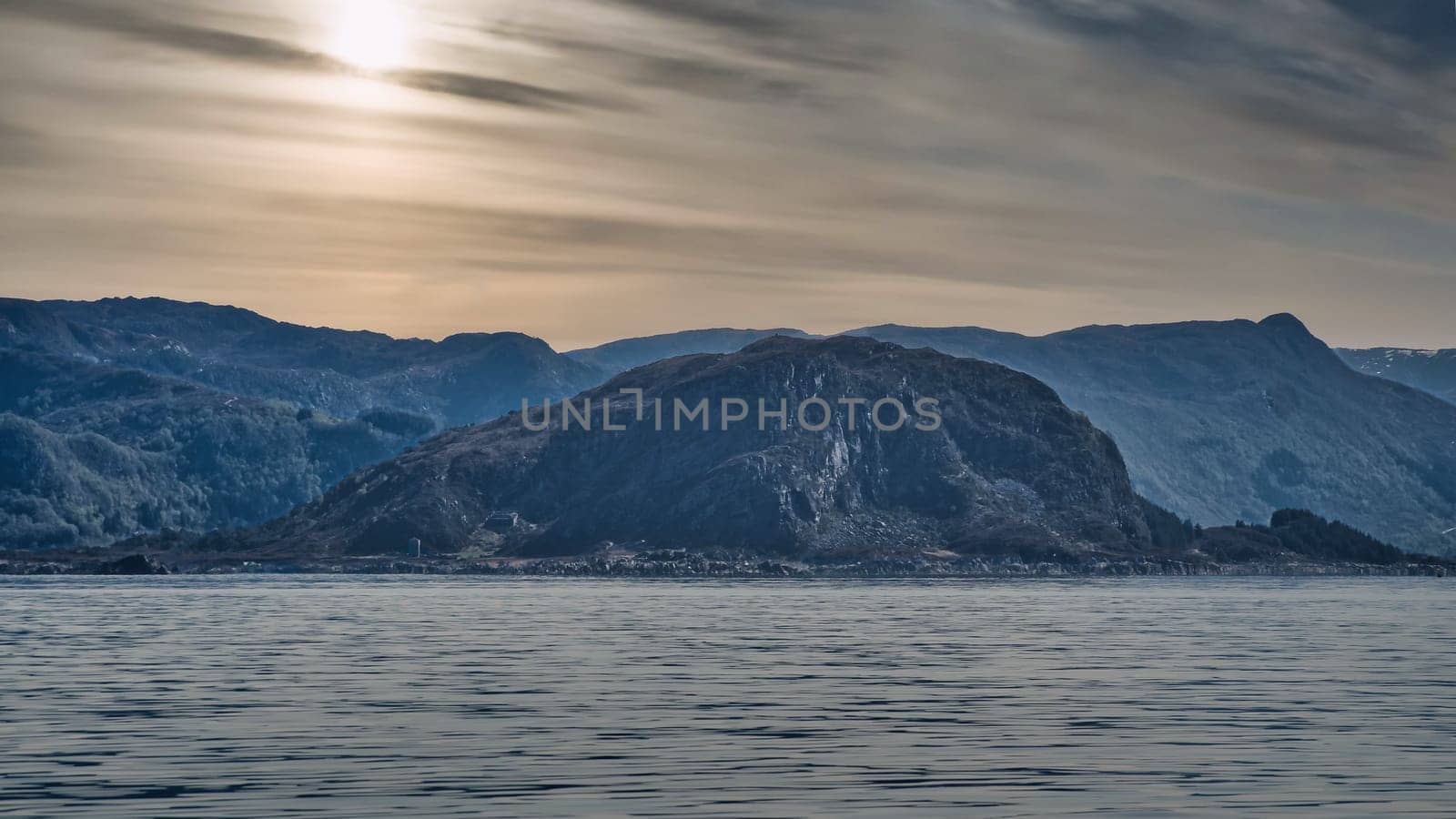 Norwegian fjord landscape. View of mountains with rugged vegetation. Crystal clear water in the foreground. Landscape from Scandinavia