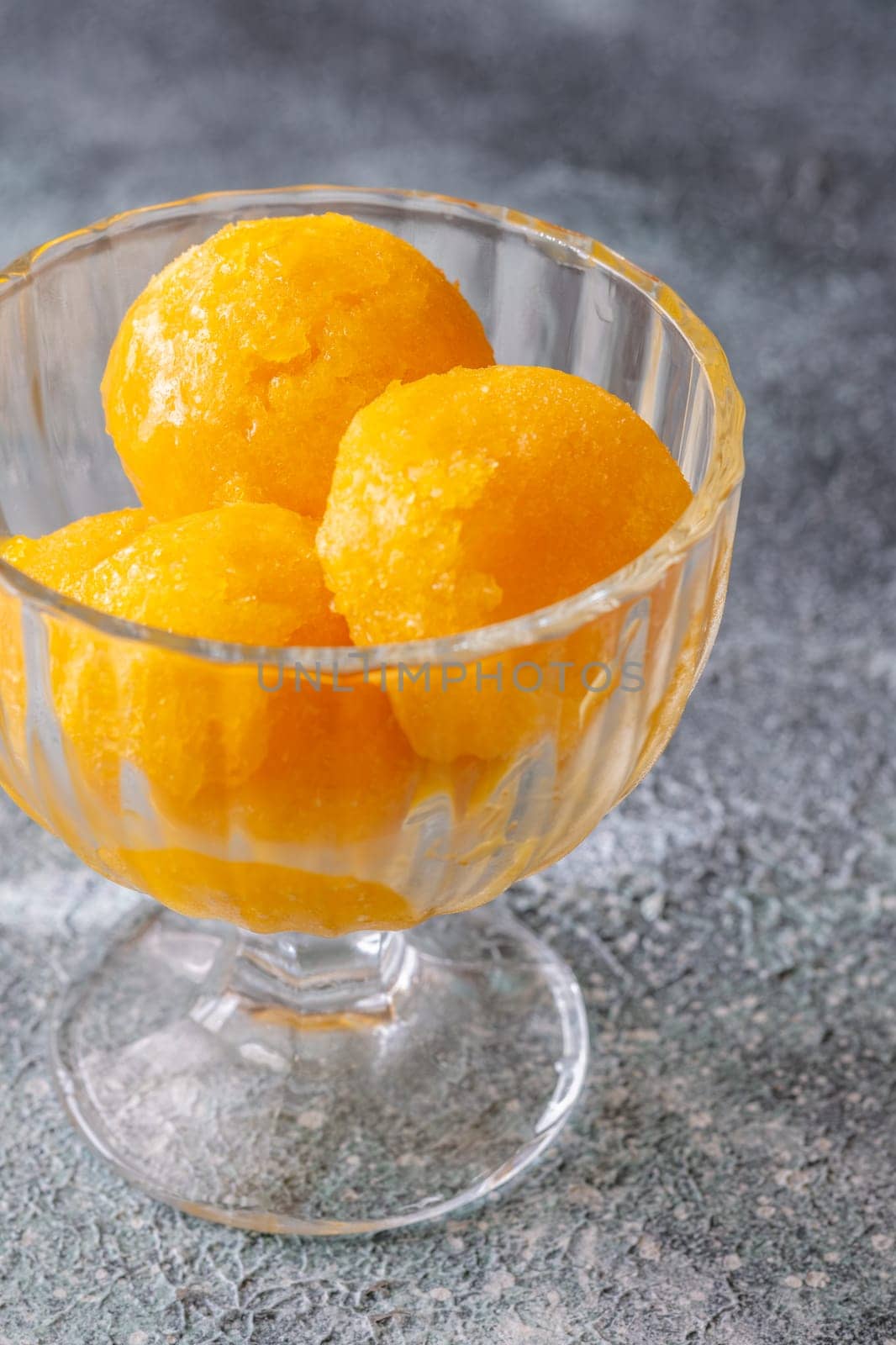 Mango sorbet scoop in the glass bowl
