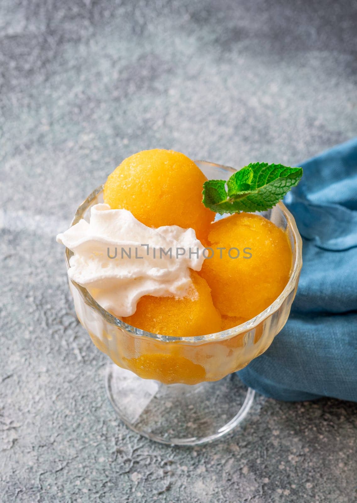Mango sorbet scoop in the glass bowl