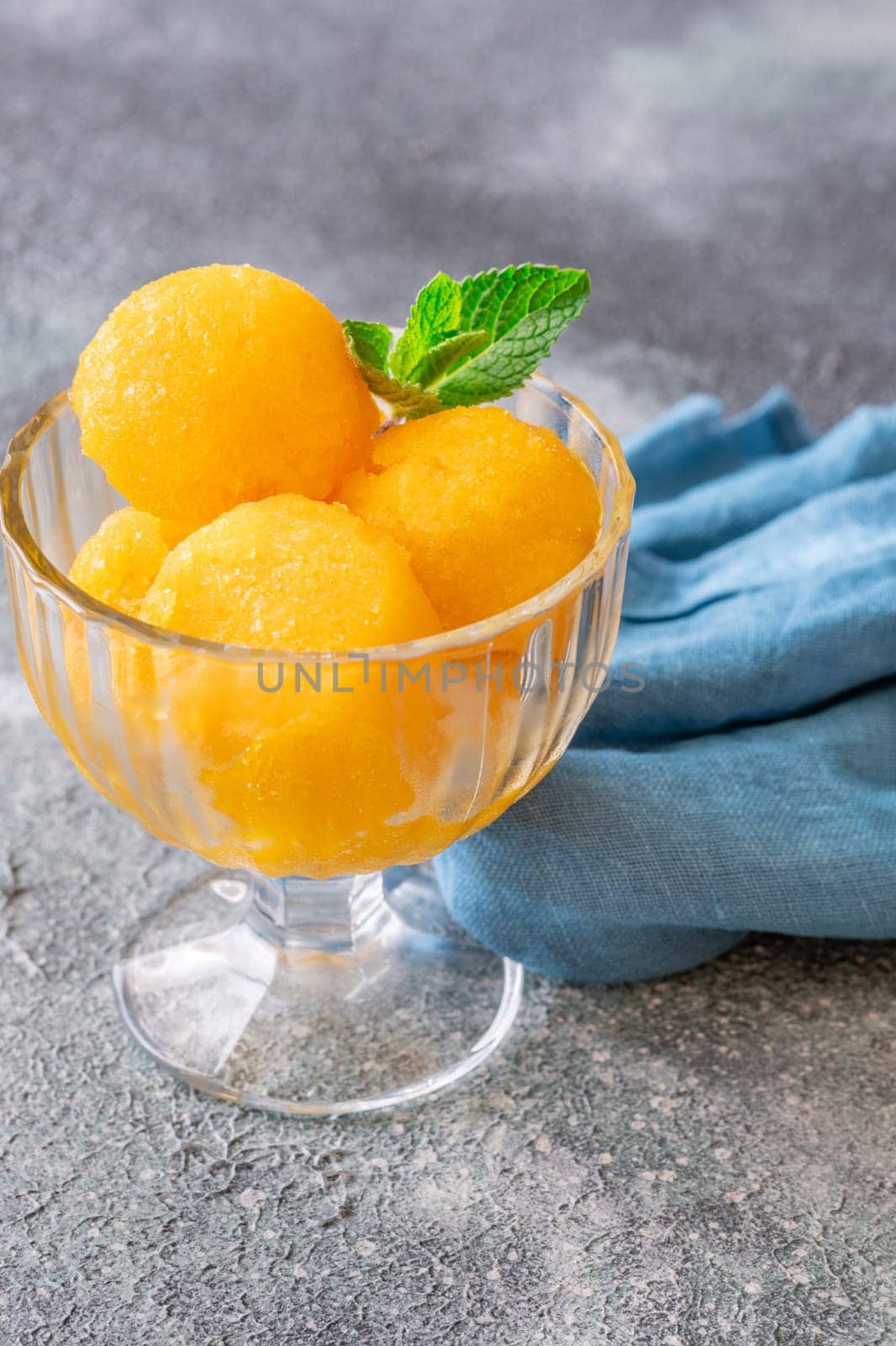 Mango sorbet scoop in the glass bowl