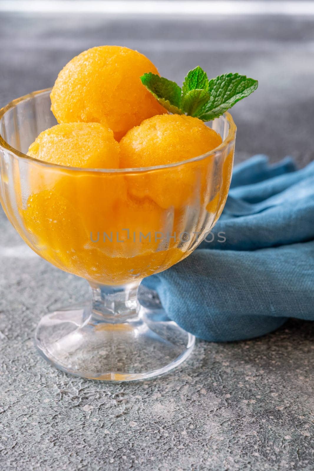 Mango sorbet scoop in the glass bowl