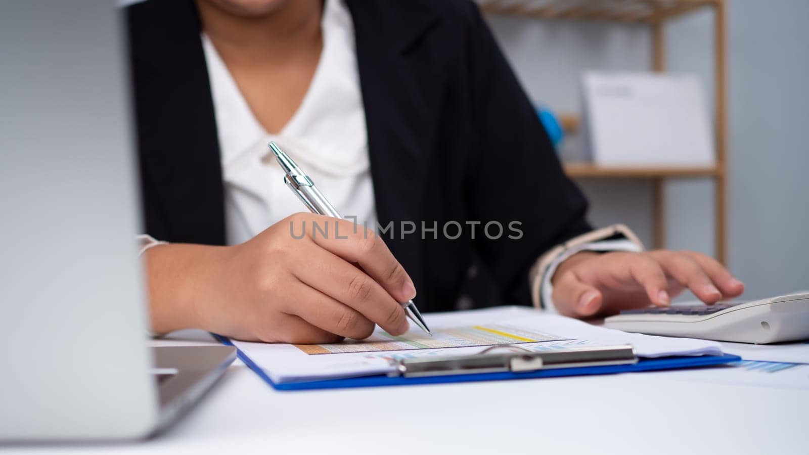 Photo close up hands of business woman working on desk office with using a calculator to calculate the numbers, Finance accounting concept, Accounting checking company budget accounting documents.