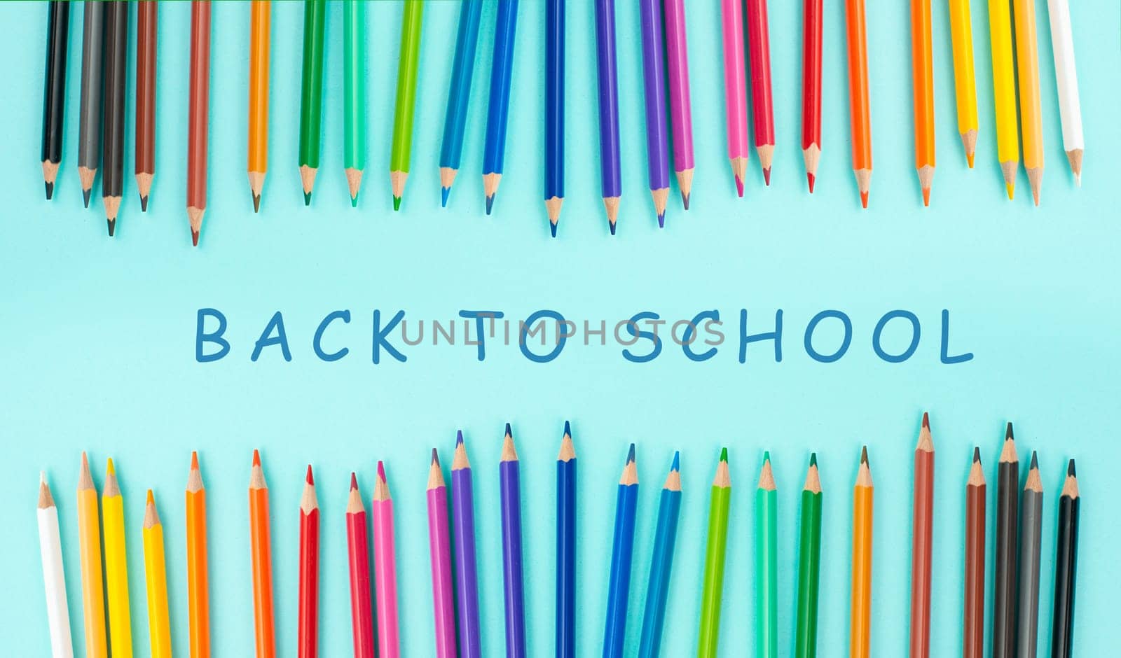 Color pencils collection in a row, back to school, drawing supplies, blue background with copy space