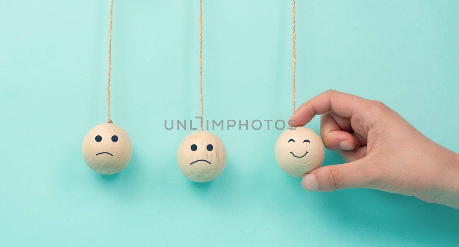 Happy smiling face spread happiness to sad faces, newton cradle concept, mental health and attitude, positive and negative mind, influence emotion, support and depression, pendulum balls