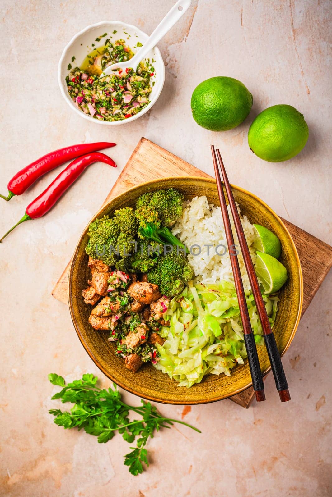 Chicken bowl with rice, broccoli, cabbage and green Chimmichurri salsa